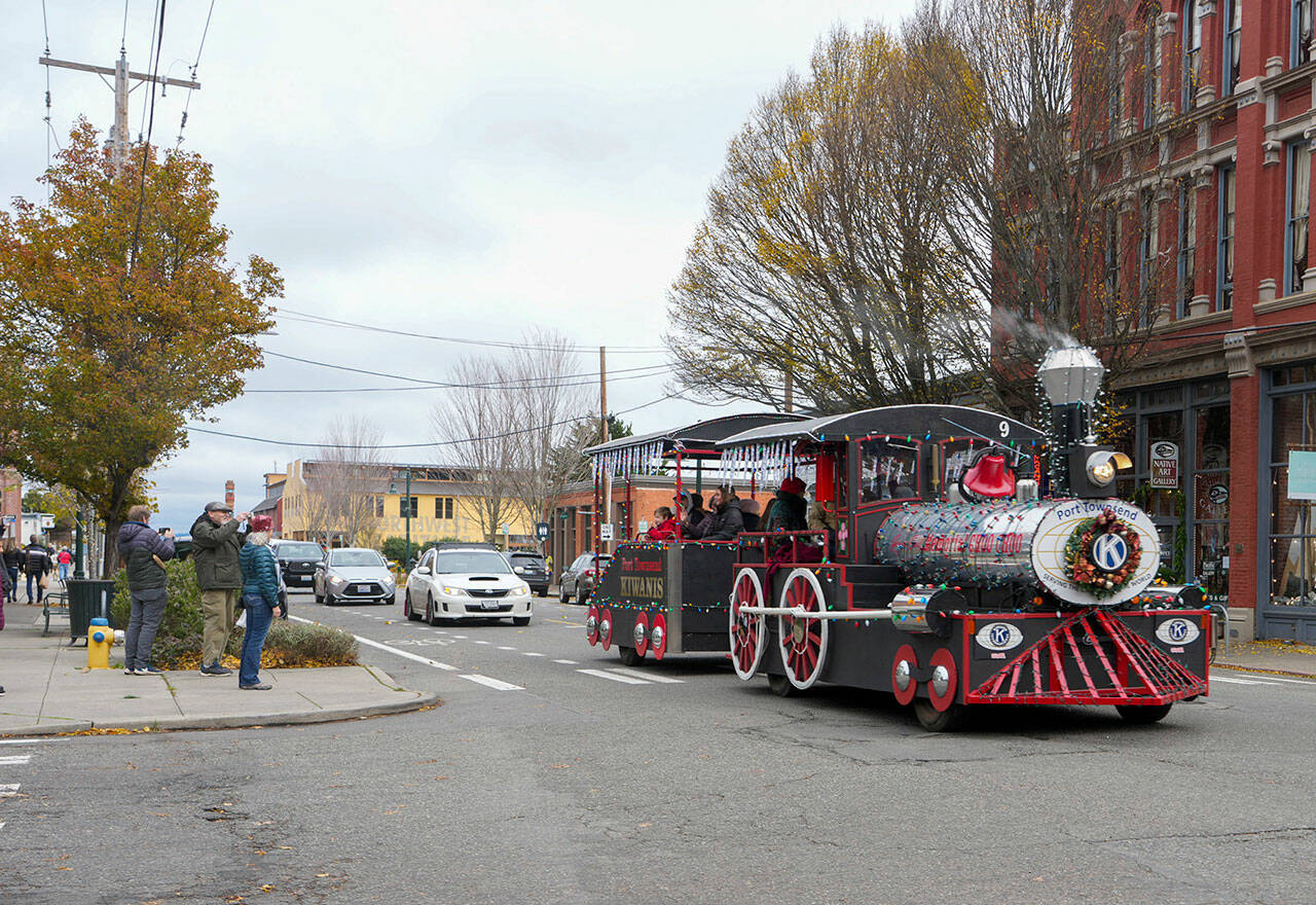 People stop and take pictures of the Port Townsend Kiwanis’ George Earl Memorial Cho Cho as it clangs along Water Street in downtown Port Townsend on Small Business Saturday. The popular Choo Choo made a circuit from the American Legion to Uptown and back again, delighting passengers and spectators alike. (Steve Mullensky/for Peninsula Daily News)