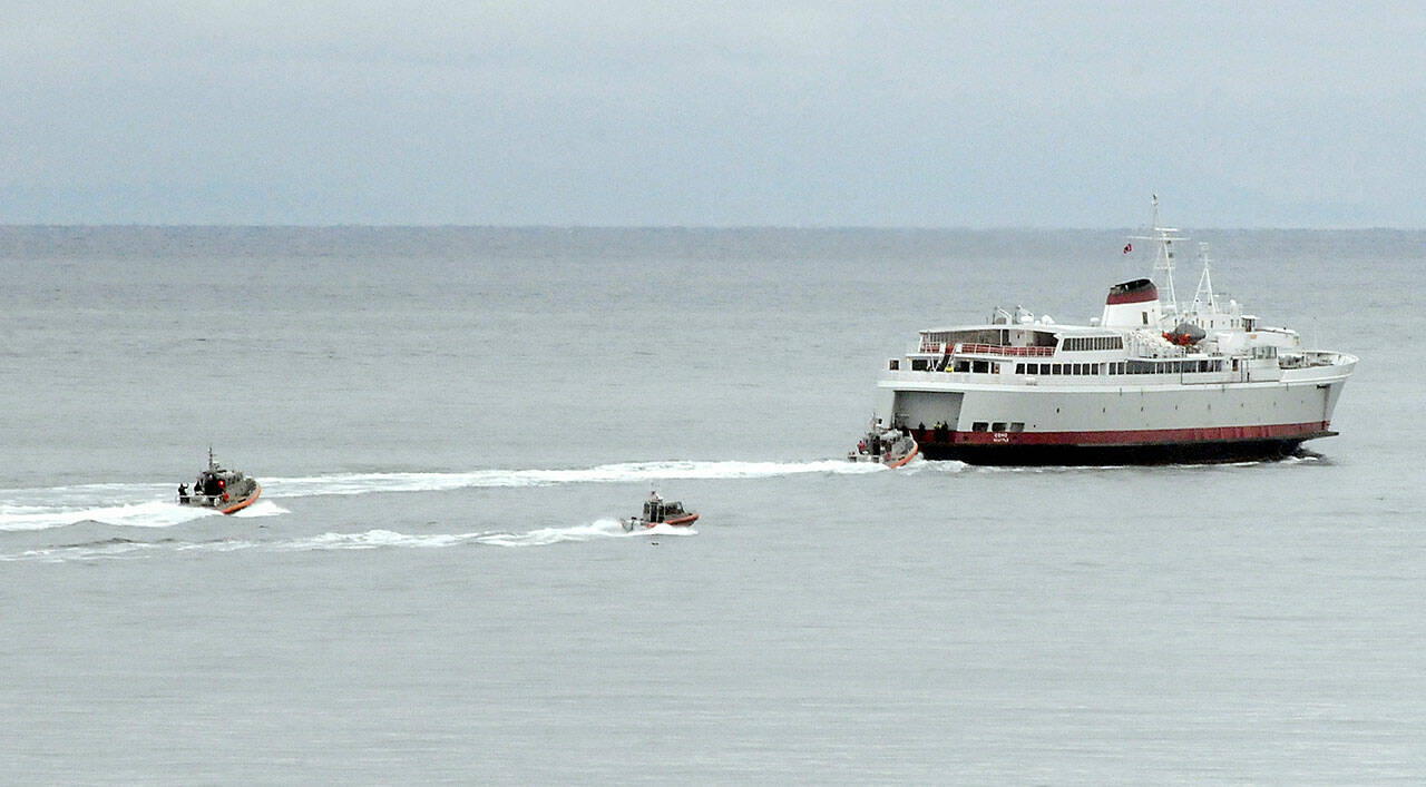 U.S. Coast Guard and law enforcement chase boats follow the ferry MV Coho during an armed passenger drill on Tuesday near the mouth of Port Angeles Harbor. (Keith Thorpe/Peninsula Daily News)