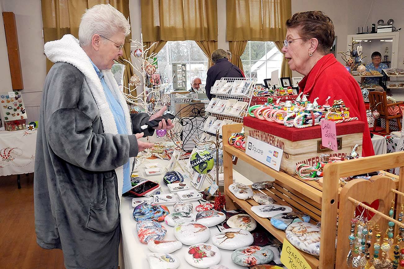 KEITH THORPE/PENINSULA DAILY NEWS
Sandie Kiehl of Sequim, left, makes a purchase from Pat Snyder of Sequim-based China Cat Creations during Saturday's Homemade Christmas Craft Fair at the Sequim Prairie Grange near Carlsborg. The event featured dozens of vendors with a wide variety of  holiday gifts and gift ideas created by local artisans.