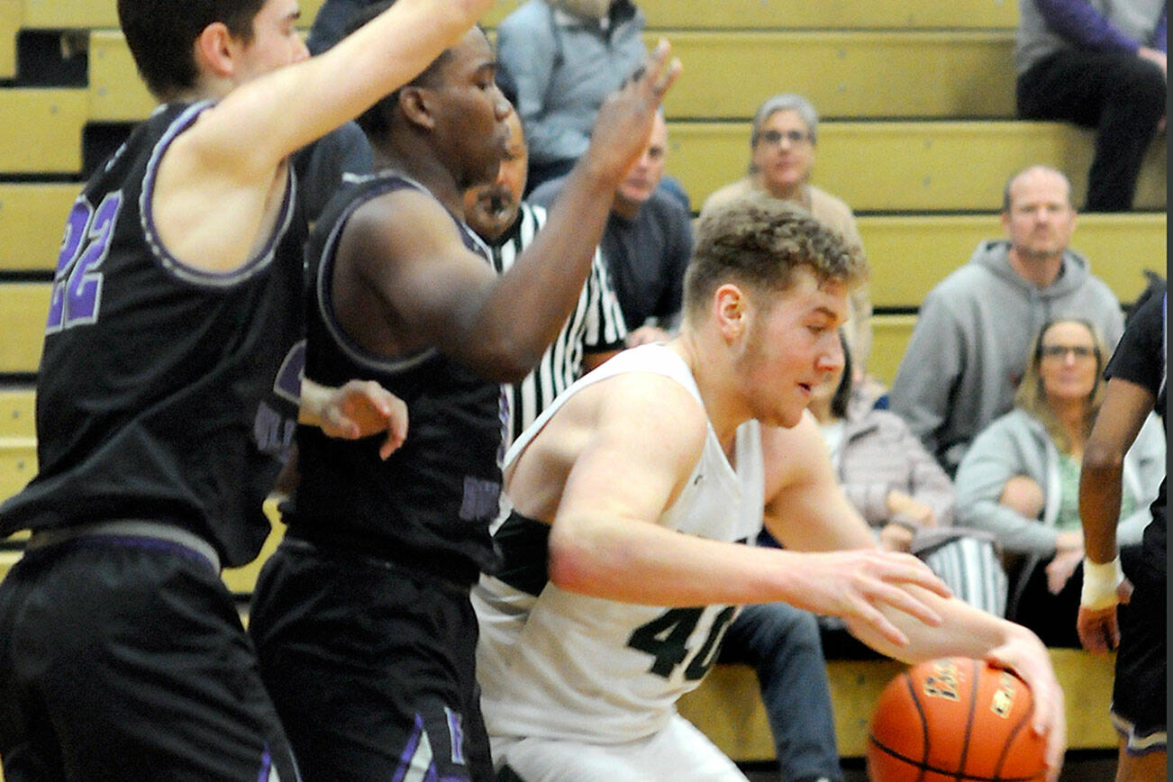 KEITH THORPE/PENINSULA DAILY NEWS
Port Angeles' Isaiah Shamp, right, leans into the defense of Foster's Liam Glanville, left, and Ronnie Toms on Saturday at Port Angeles High School.
