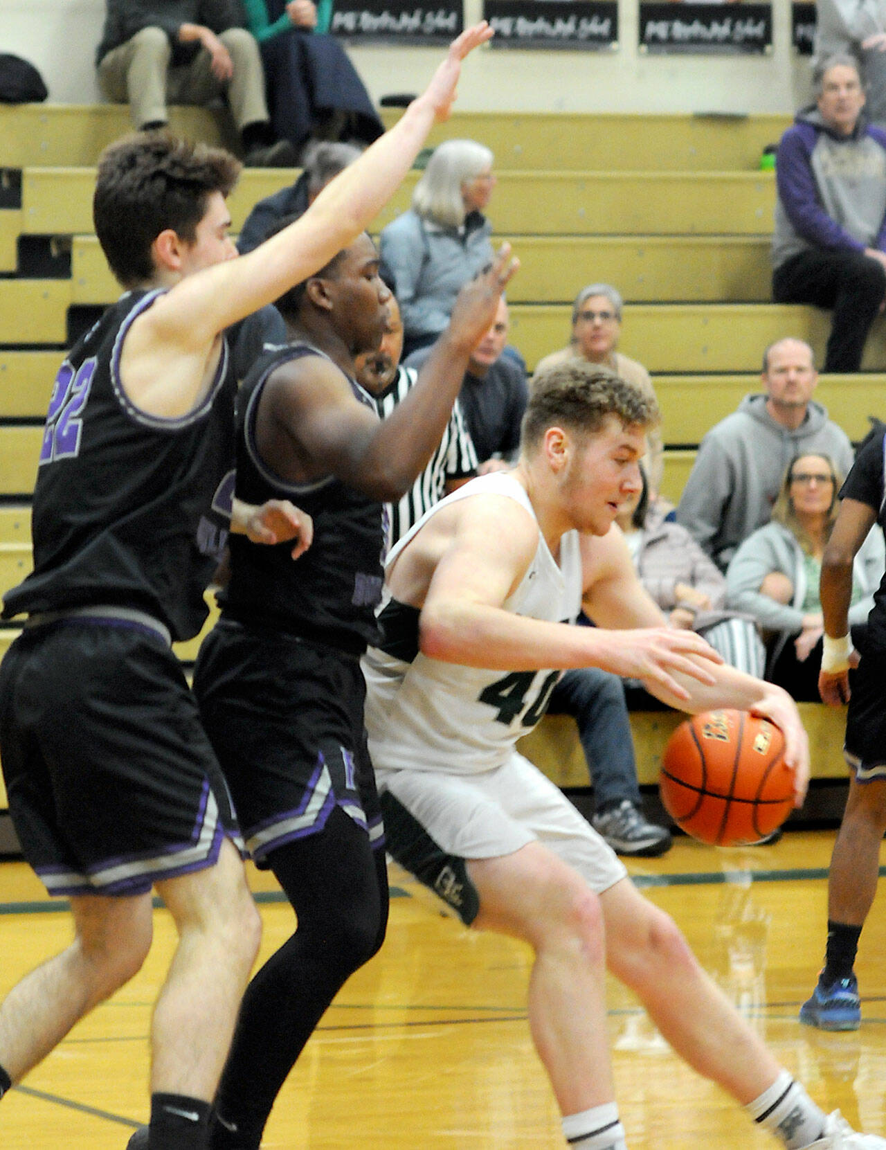 Port Angeles’ Isaiah Shamp, right, leans into the defense of Foster’s Liam Glanville, left, and Ronnie Toms on Saturday at Port Angeles High School. Shamp led the Riders with 28 points. (Keith Thorpe/Peninsula Daily News)
