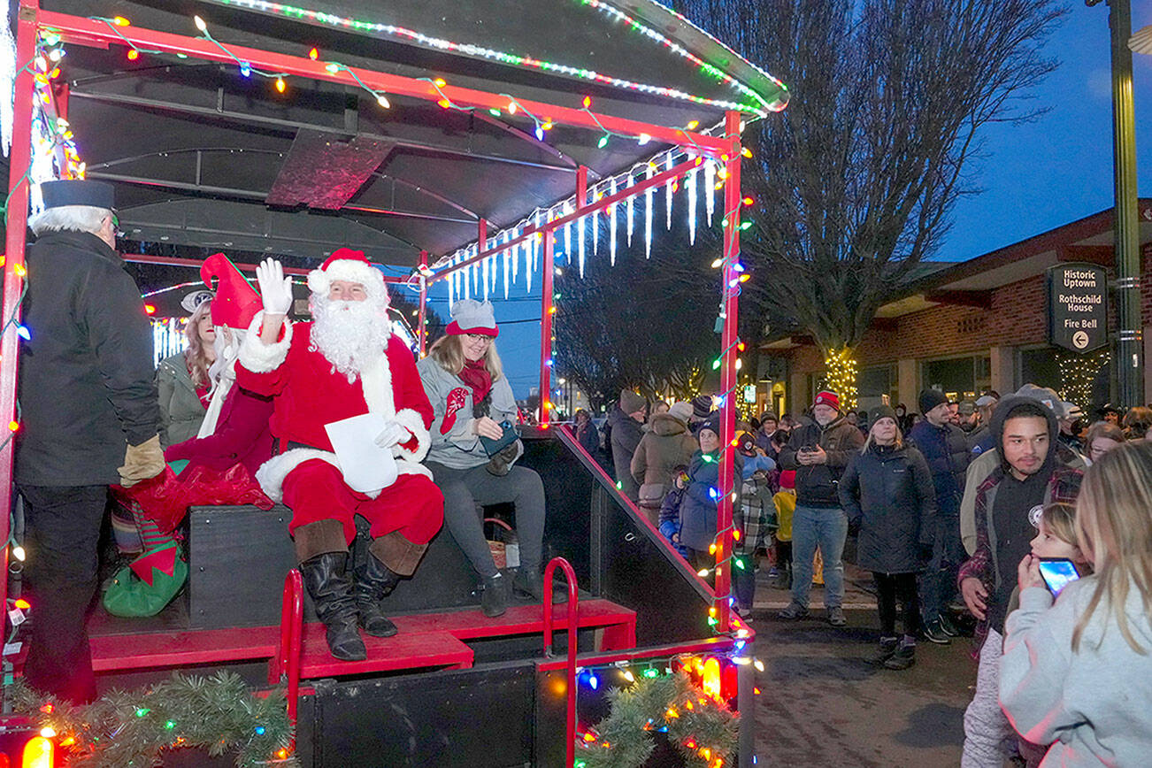 Santa waves to his fans as he arrives at Haller Fountain aboard the Kiwanis Choo Choo in downtown Port Townsend on Saturday to oversee the lighting of the community tree. (Steve Mullensky/for Peninsula Daily News)