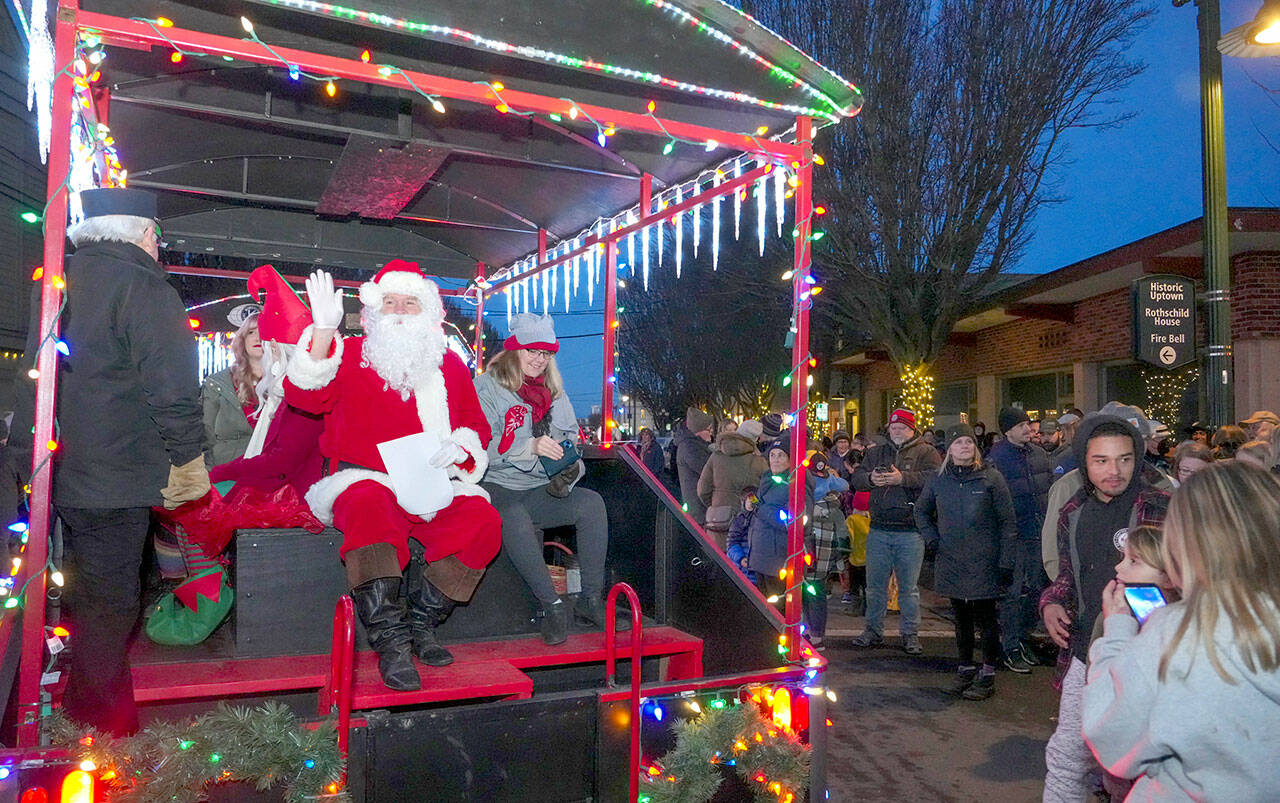 Santa waves to his fans as he arrives at Haller Fountain aboard the Kiwanis Choo Choo in downtown Port Townsend on Saturday to oversee the lighting of the community tree. (Steve Mullensky/for Peninsula Daily News)