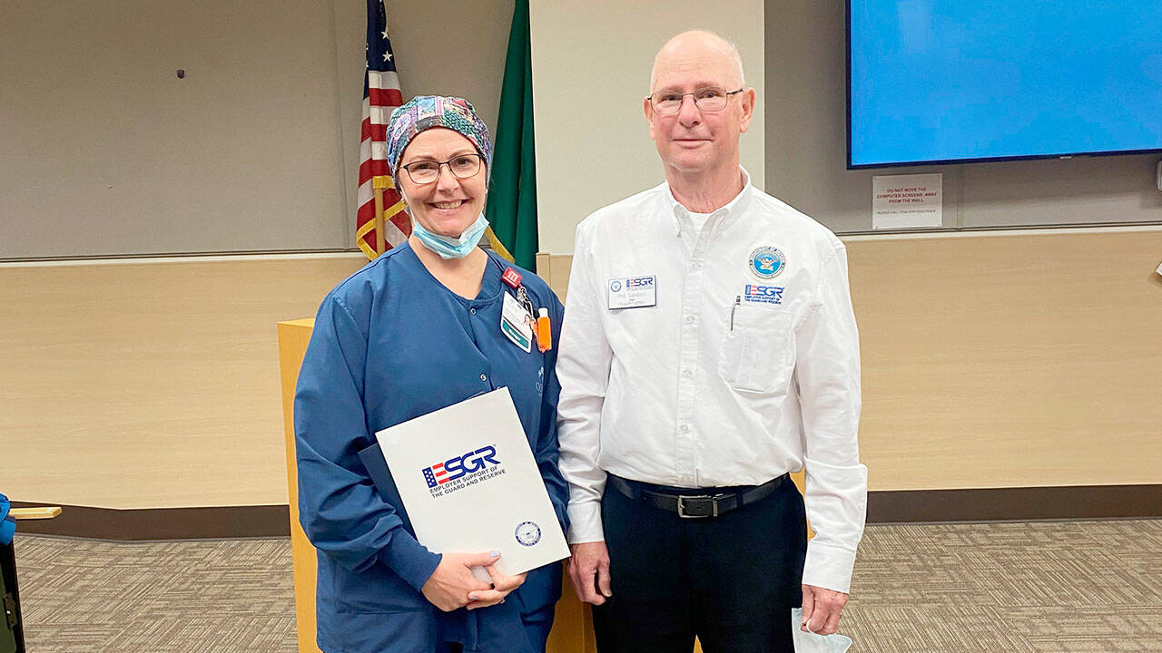 Sarah Winfield, on left, accepts the Patriot Award from Phil Sanders, Washington state chair of the Employer Support of the Guard and Reserve.