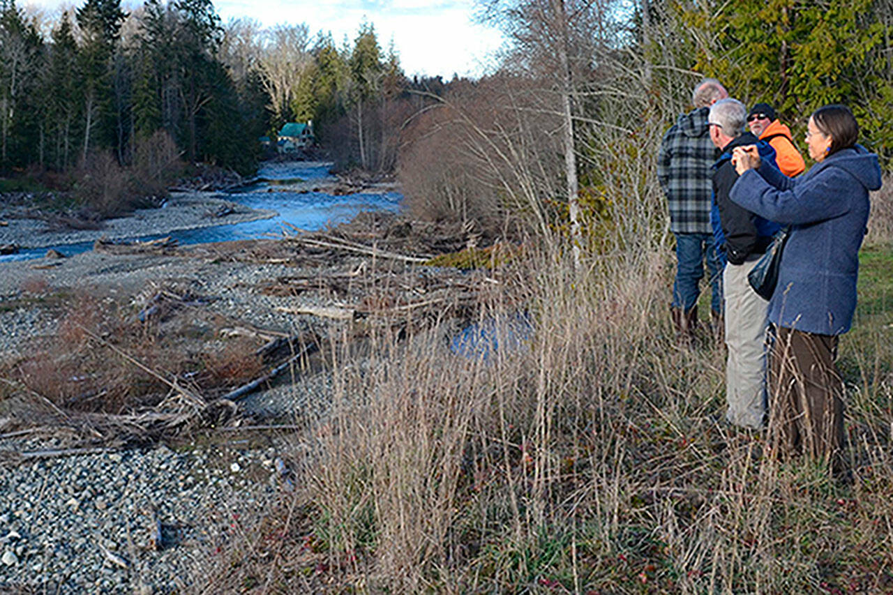 Visitors look at the Dungeness River near the site in 2017 where Clallam County officials continue to seek support for the Dungeness Off-Channel Reservoir. (Matthew Nash/Olympic Peninsula News Group)