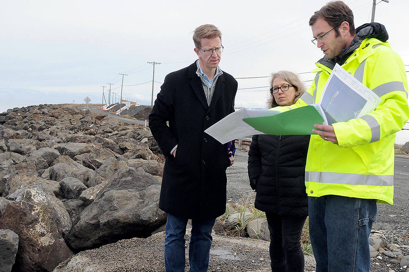 KEITH THORPE/PENINSULA DAILY NEWS
U.S. Rep. Derek Kilmer, left, looks over revetment repair plans with Port Angeles Mayor Kate Dexter and city engineer Jonathan Boehme, right, during a visit to Ediz Hook in Port Angeles on Friday.