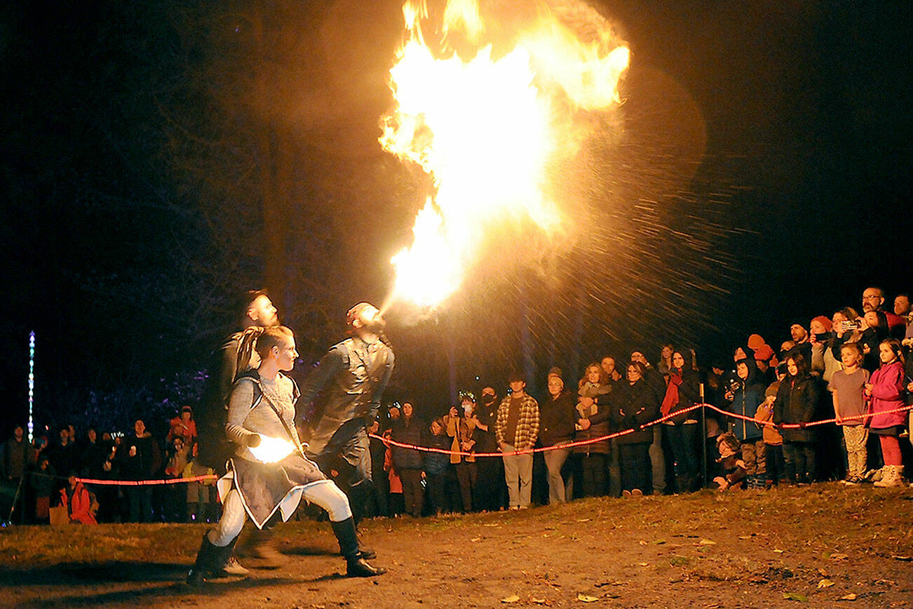 Members of The Fractal Phase, from front, Nova Cain, Pumba Burns and Ahnrix Bishop, breathe fire and preform dance with flames during Saturday’s Wintertide Festival of Light at the Port Angeles Fine Arts Center. The event featured music, entertainment, a lantern parade and other yule activities to celebrate the winter solstice. (Keith Thorpe/Peninsula Daily News)