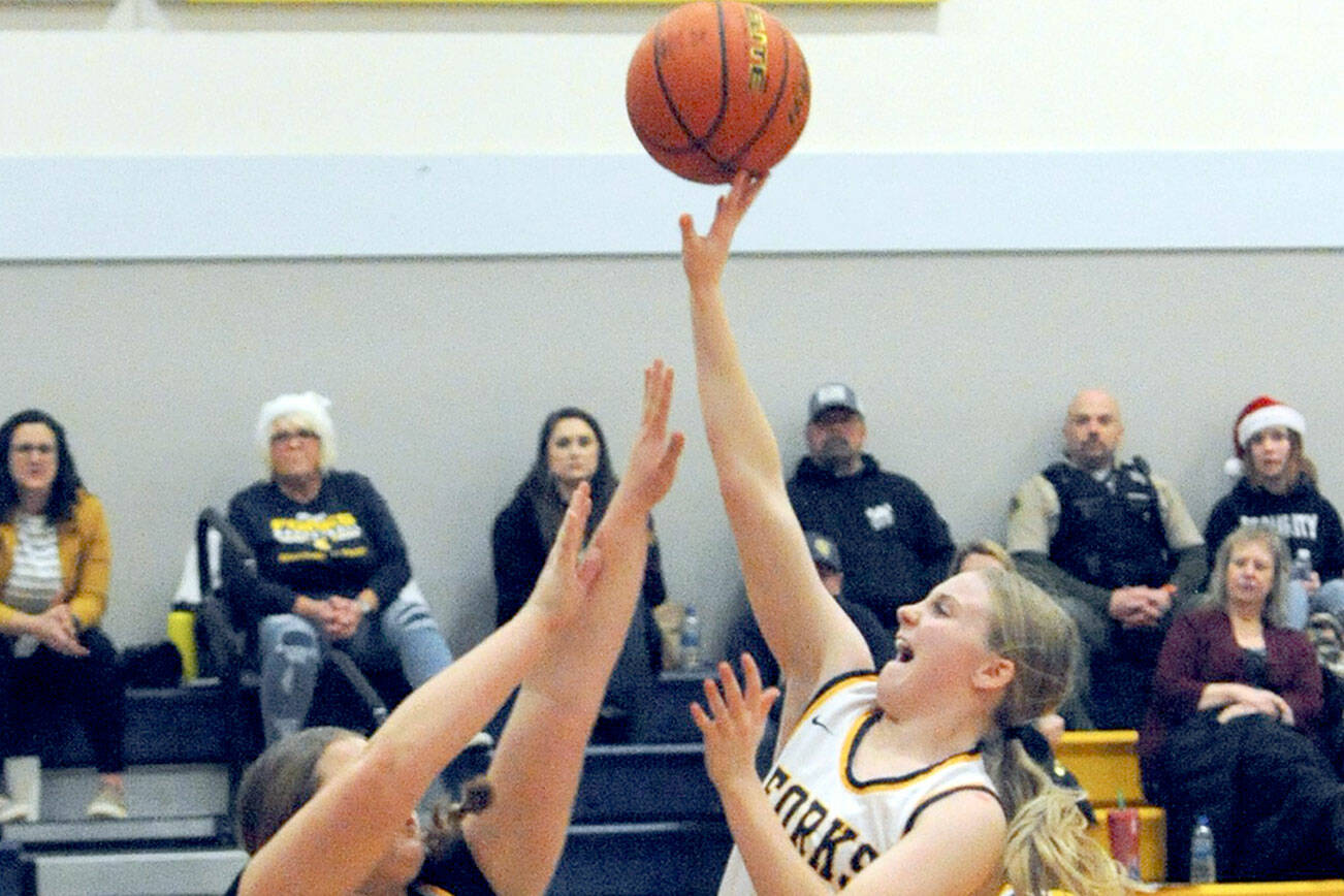 Lonnie Archibald/for Peninsula Daily News
Forks' Kadie Wood scores over Ilwaco's Olivia McKinstry during the Spartans' 75-64 win over Ilwaco at home Wednesday.