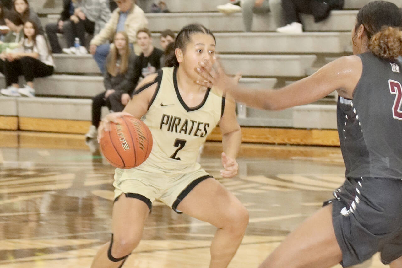 Peninsula’s Tati Kamae (2) brings the ball up against Pierce College’s Tyra Brown (23) Sunday. Kamae had 18 points and a school-record 14 steals in a 63-41 win. (Dave Logan/for Peninsula Daily News)