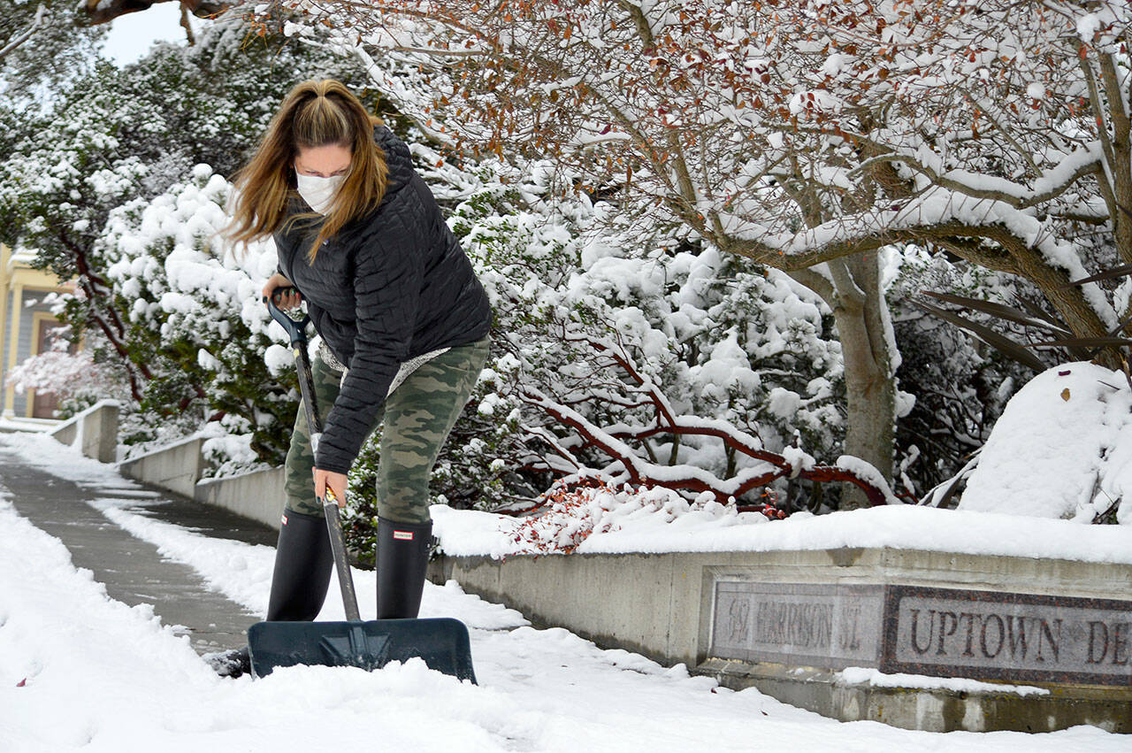 Danelle Greer, staffer at the Uptown Dental Clinic in Port Townsend, clears the sidewalk around Lawrence Street on Tuesday afternoon. (Diane Urbani de la Paz/for Peninsula Daily News)
