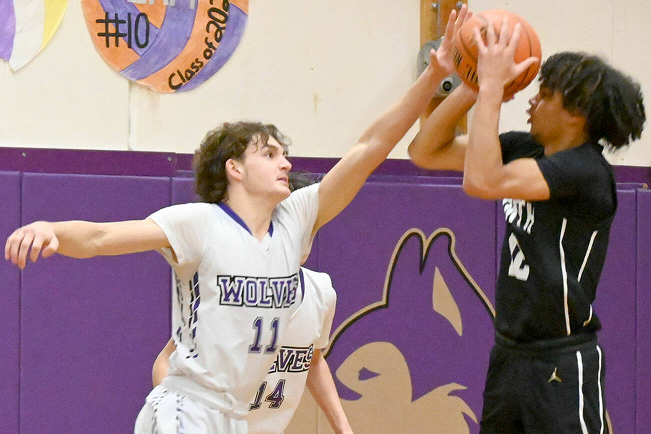 Michael Dashiell/Olympic Peninsula News Group
Sequim's Charlie Grider gets his hands in the face of a jump shot taken by North Kitsap's Harry Davies on Monday at Sequim High School.