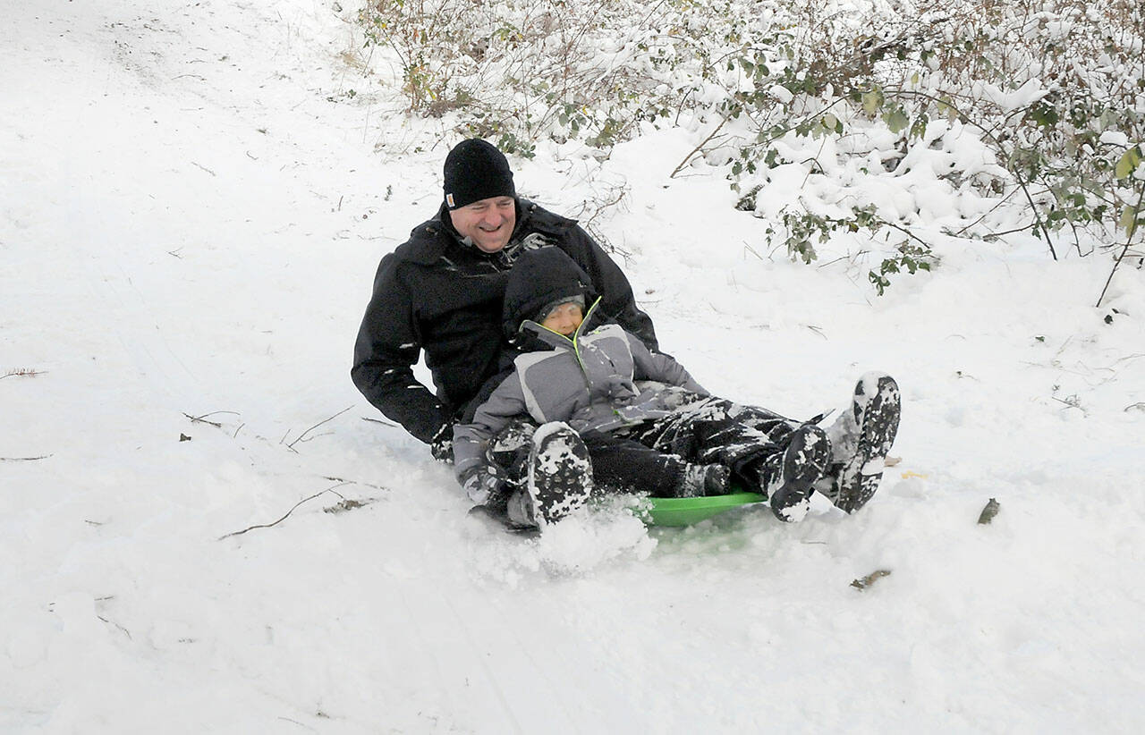 Nicholas Strang of Port Angeles and his son, Colton, 5, careen down a small hill on a sled at Shane Park in Port Angeles on Wednesday. (Keith Thorpe/Peninsula Daily News)