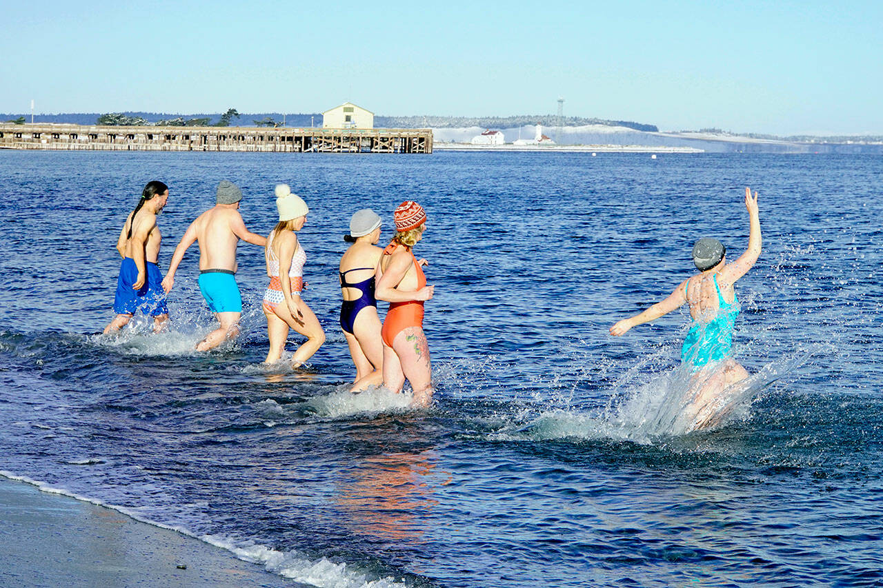 A group of Port Townsend friends decided the best way to celebrate the winter Solstice was to take a swim in the frigid waters of the Salish Sea on Wednesday afternoon. Comments heard as they came out were exhilarating and refreshing before they stood around a fire to get warm. (Steve Mullensky/for Peninsula Daily News)