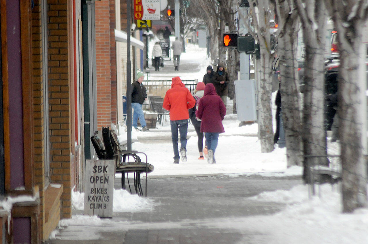 Pedestrians make their way along an icy stretch of First Street in downtown Port Angeles on a sub-freezing Thursday afternoon. (Keith Thorpe/Peninsula Daily News)