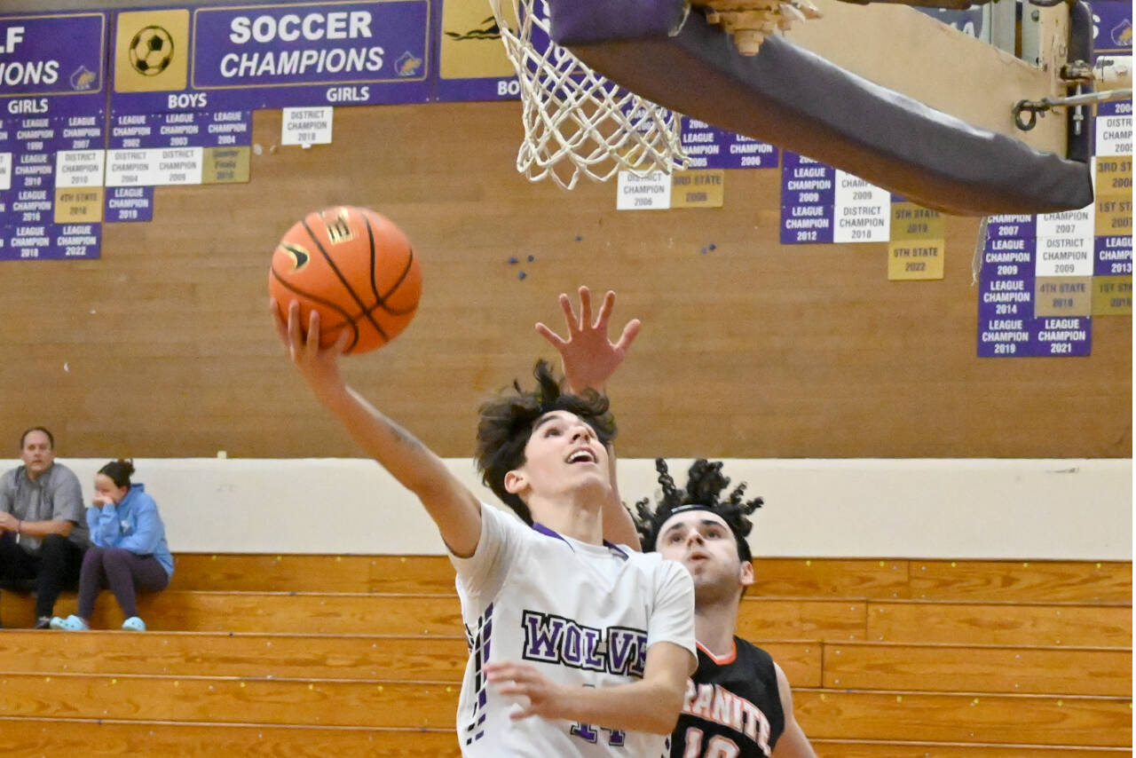 Sequim's Vincent Carrisoza to the rim defended by Granite falls' Marcus Klammt on Thursday. Sequim won 78-43. (Michael Dashiell/Olympic Peninsula News Group)