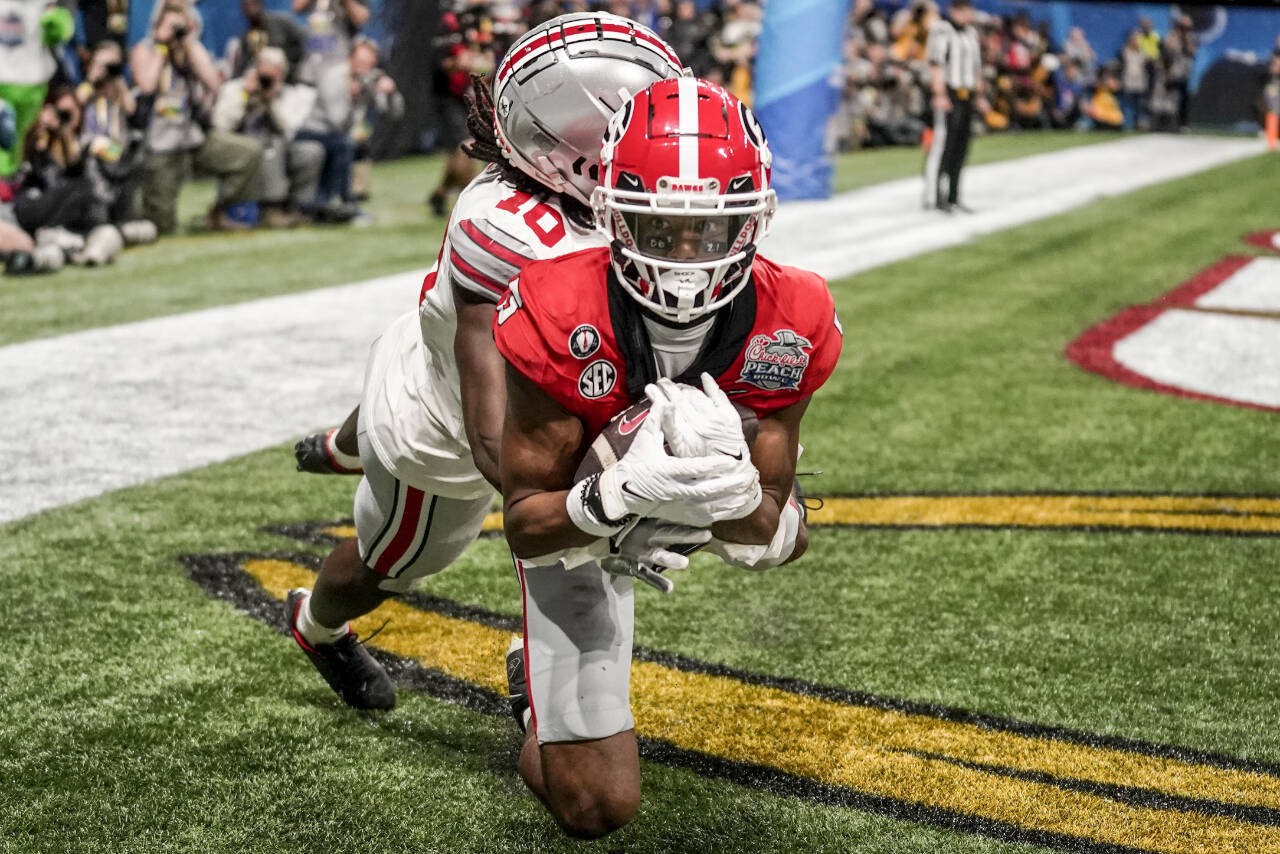 Georgia wide receiver Adonai Mitchell (5) makes a touchdown catch against Ohio State cornerback Denzel Burke (10) during the second half of the Peach Bowl NCAA college football semifinal playoff game, Saturday, Dec. 31, 2022, in Atlanta. (AP Photo/Brynn Anderson)