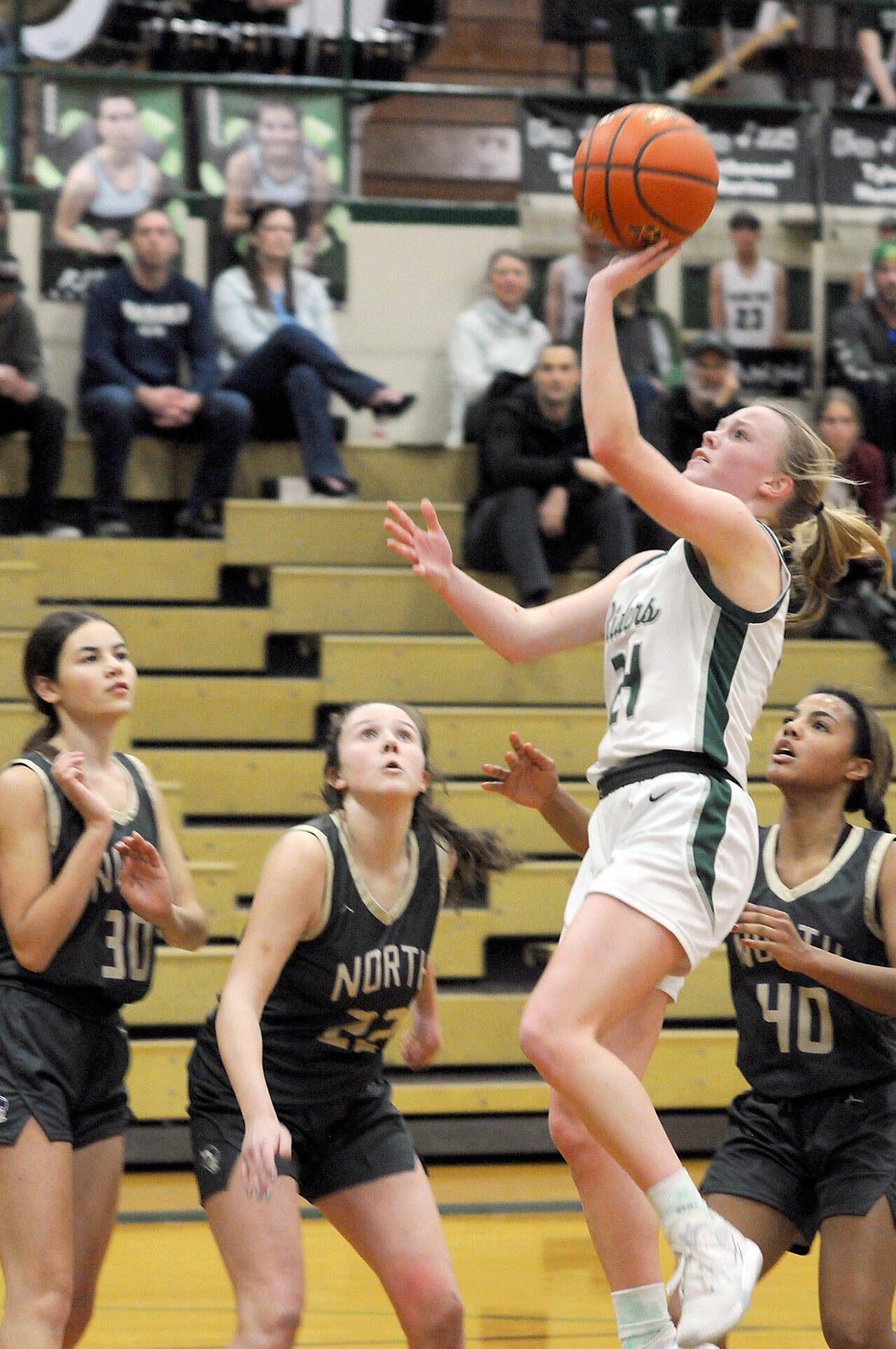 Port Angeles’ Anna Petty, front, goes for the quick layup as North Kitsap defenders, from left, Megan Komar, Teegan DeVries and Coriana McMillian look on during Tuesday’s game at Port Angeles High School. (Keith Thorpe/Peninsula Daily News)