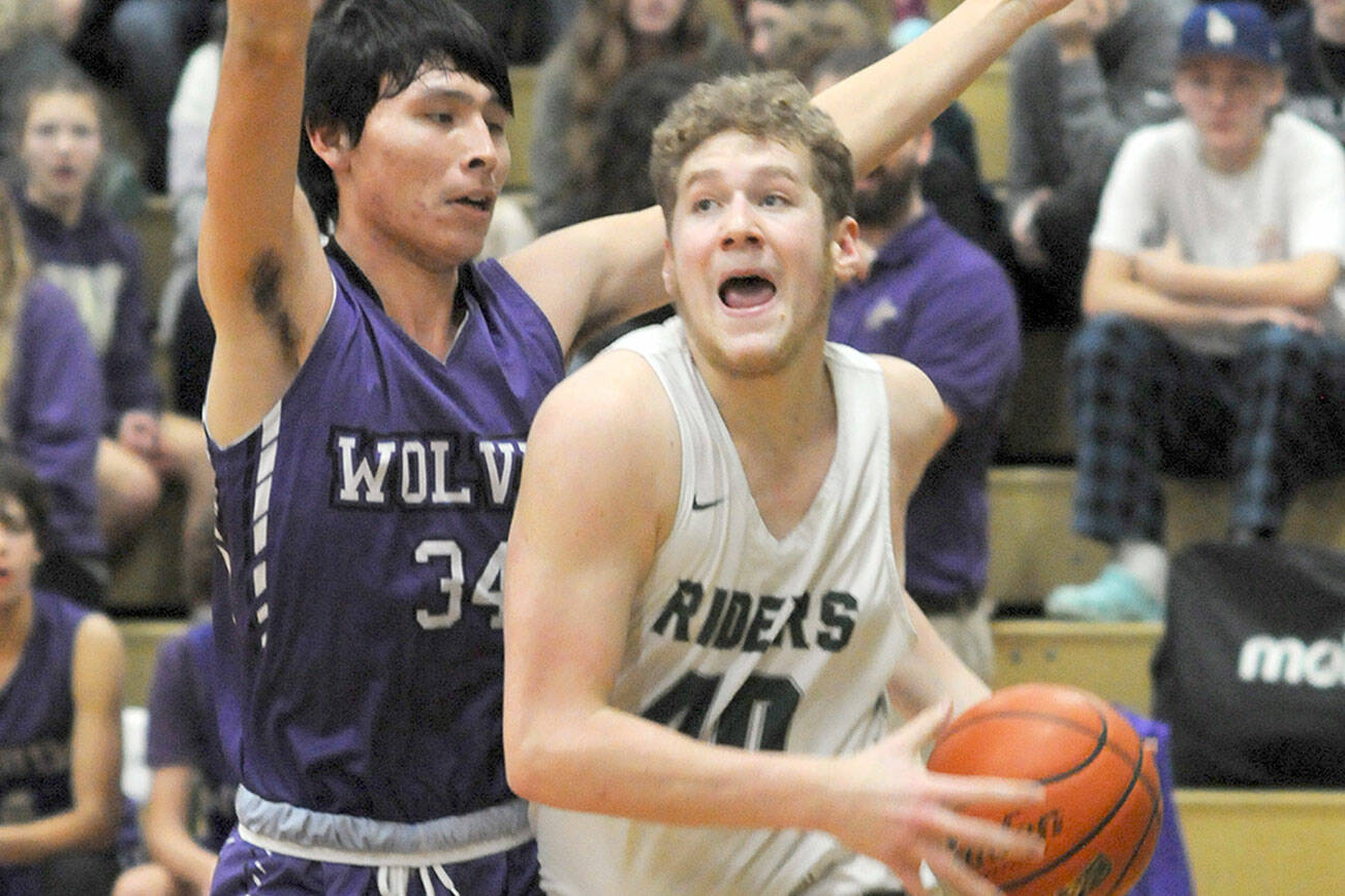 KEITH THORPE/PENINSULA DAILY NEWS
Port Angeles' Isaiah Shamp, right, pushes past Sequim's Isaiah Moore on the way to the lane on Tuesday night in Port Angeles.