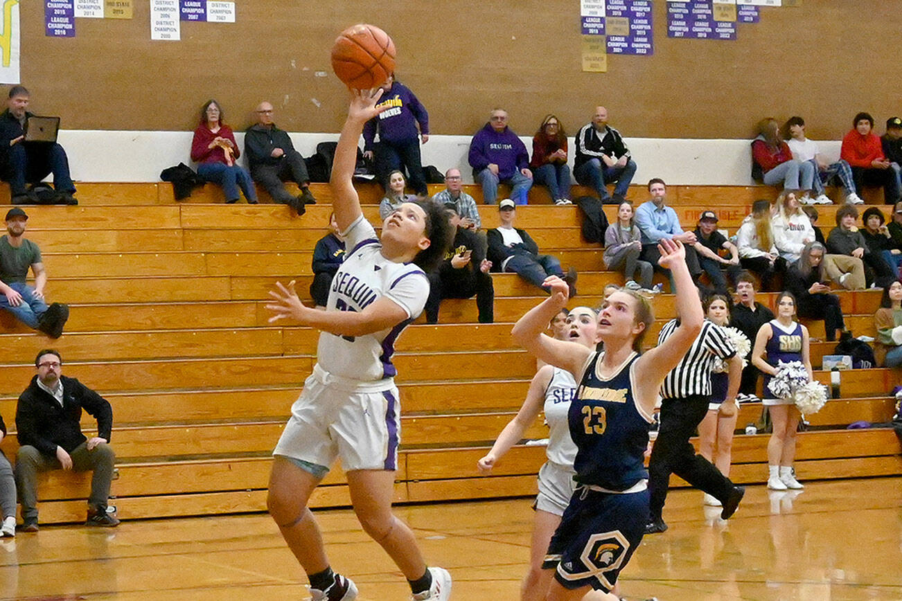 Michael Dashiell/Olympic Peninsula News Group
Sequim's Bobbi Mixon goes up for a layup while Bainbridge's Sierra Berry and Sequim's Hannah Bates look on during the Wolves' win Thursday.