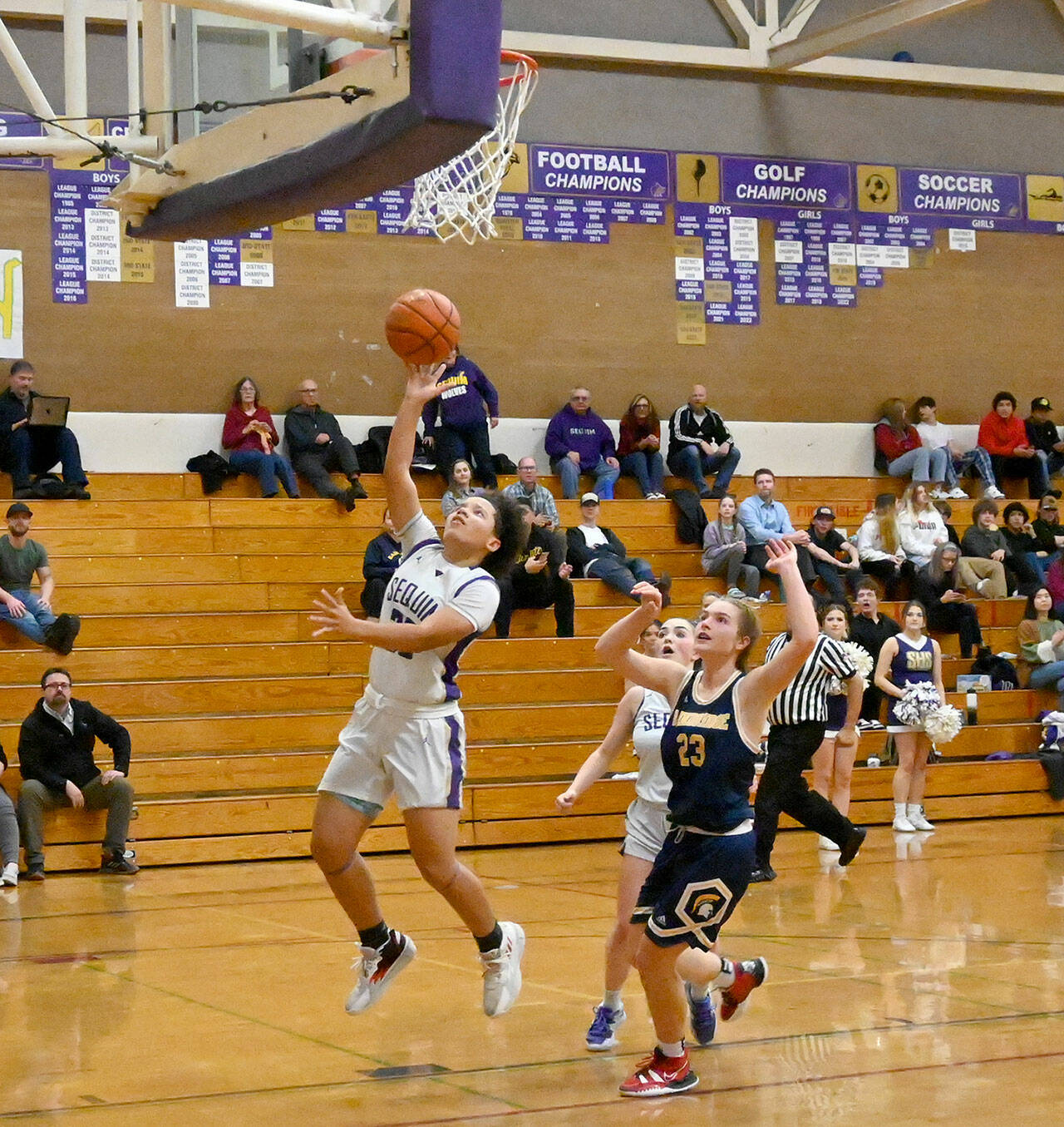 Michael Dashiell/Olympic Peninsula News Group Sequim’s Bobbi Mixon goes up for a layup while Bainbridge’s Sierra Berry and Sequim’s Hannah Bates look on during the Wolves’ win Thursday.