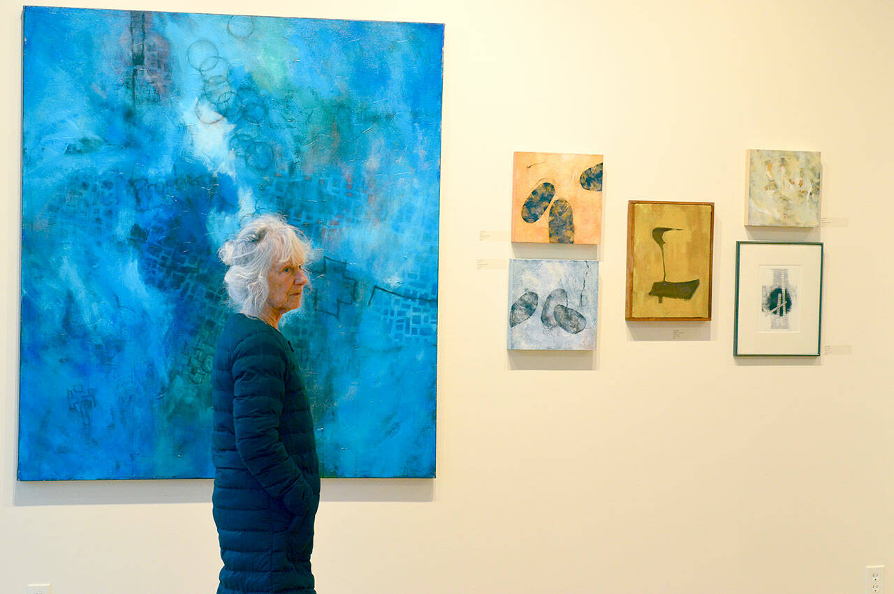 Toni Wilhelm of Port Townsend visits “One from the Art,” an exhibition of Jay Haskins’ work, at Northwind Art’s Jeanette Best Gallery. (Diane Urbani de la Paz/For Peninsula Daily News)
