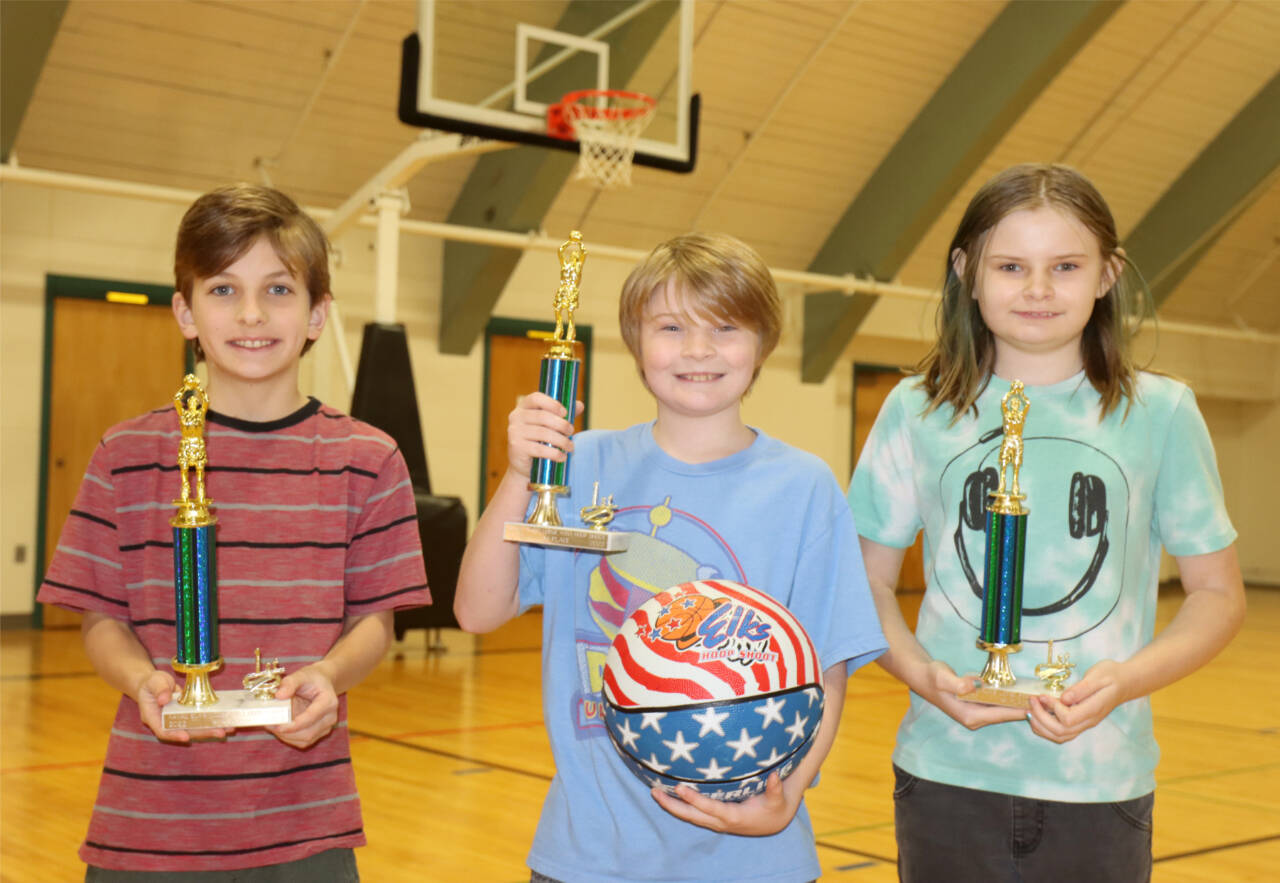 The first-place Elks Hoop Shoot Winners from the city championships held this weekend at the Vern Burton Gym receive tehir trophies. From left, they are Levi Simoneau, 11, from Franklin Elementary School, who shot 18 out of 25 to win the boys 10-11 age group; Logan Wasnock, 8, from Jefferson Elementary, who shot 13 out of 25 to win the boys 8-9 age group; and Lillian Wasnock, 11, from Jefferson Elementary, who shot 10 out of 25 to win the girls 10-11 age group. Second-place winners were James Boyd, 13 out of 25 in the 8-9 age group and Ernest Grimes Jr., 14 out of 25 in the 10-11 age group. The first-place winners will compete in the district championship this Saturday at Vern Burton Gym. (Dave Logan/for Peninsula Daily News)