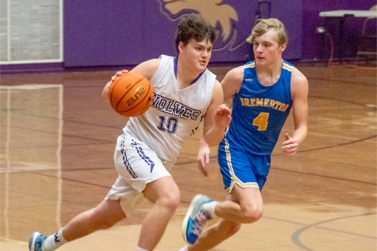 Sequim's Keenan Green, (10), drives by Bremerton's Trenton Bulmer, (4), in the Wolves' 60-49 Olympic 2A League win over the Knights Tuesday. (Emily Matthiessen/Olympic Peninsula News Group)