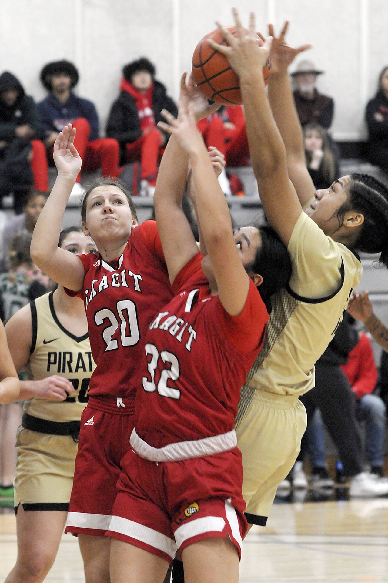 KEITH THORPE/PENINSULA DAILY NEWS
Peninsula's Ituau Tuisaula, right, reaches for a rebound over the heads of Skagit Valley's McKenna Wichers, left, and Sarah Cook as Pennsula's Ruth Moss looks on from behind on Wednesday night in Port Angeles.