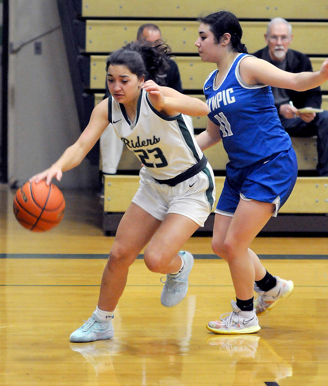 KEITH THORPE/PENINSULA DAILY NEWS Piper Williams of Port Angeles dribbles in on the baseline as Olympic’s Angelina Godinez-Gonzalez guards the approach on Thursday night at Port Angeles High School.