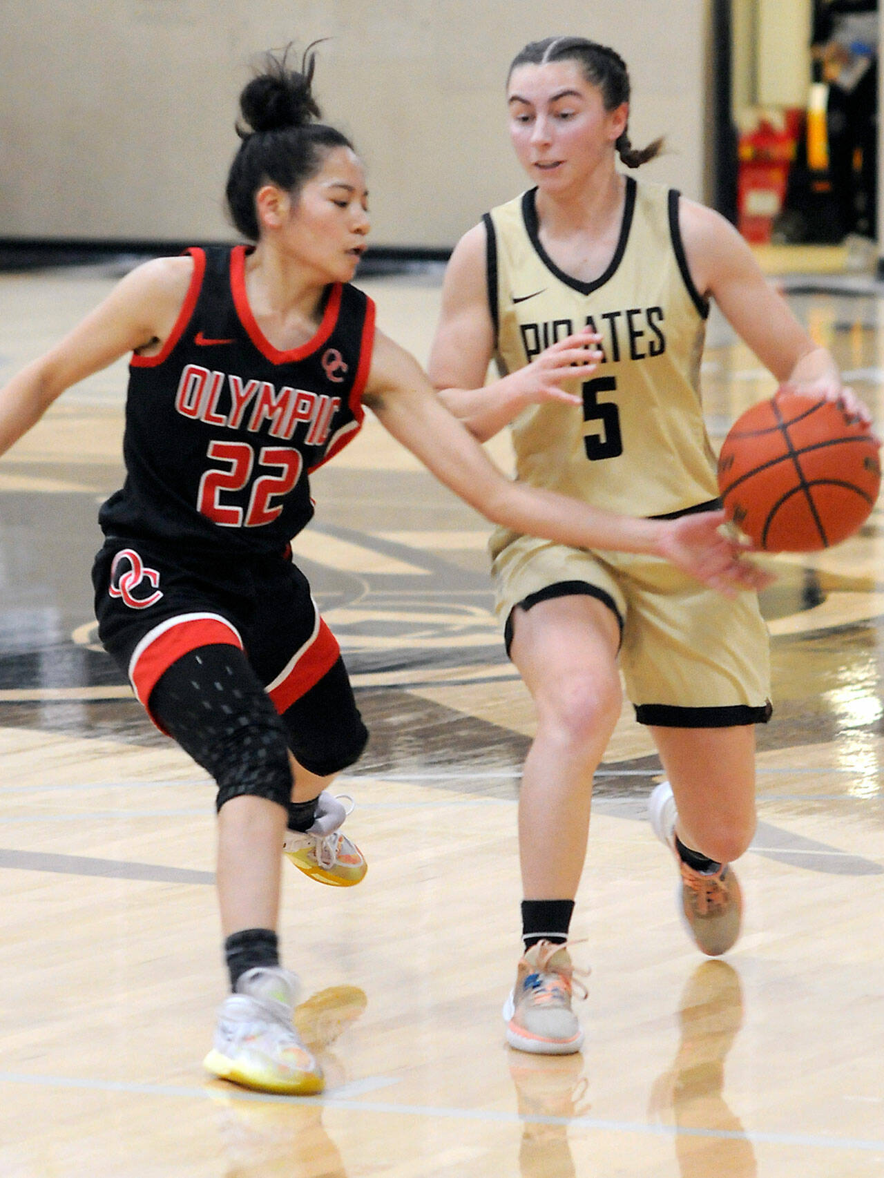 Peninsula’s Talia Marini, right, drives downcourt as Olympic’s Missy May Valdez tries to tip away the ball on Saturday in Port Angeles. (Keith Thorpe/Peninsula Daily News)