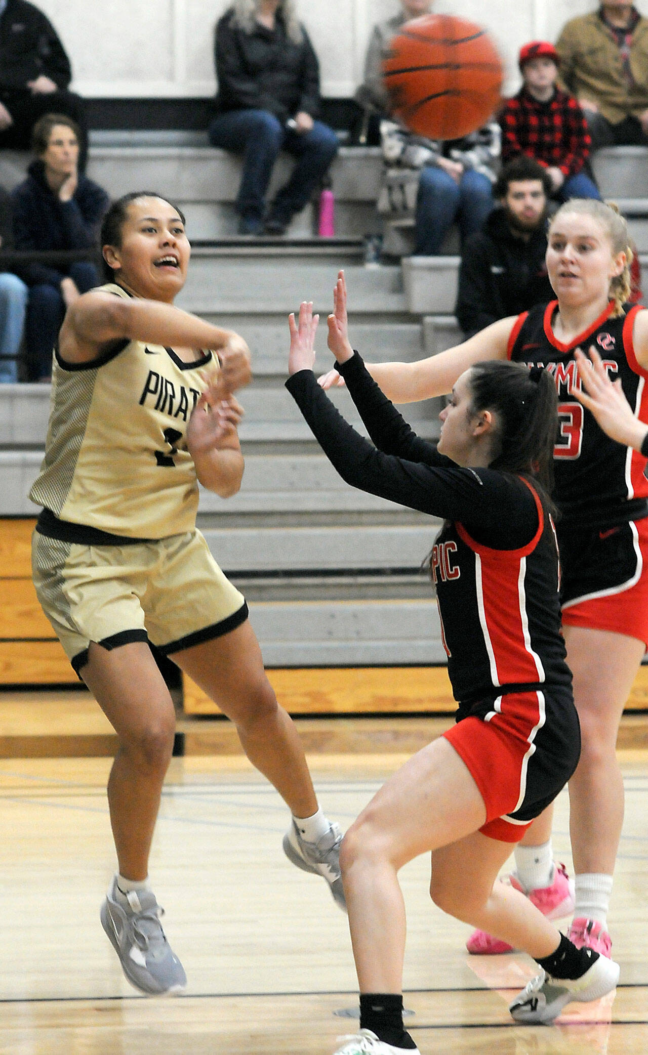 Peninsula’s Tatianna Kamae, left, passes over the head of Olympic’s Madilyn Neil as Olympic’s Alannah Northam looks on at right during Saturday’s game in Port Angeles. (Keith Thorpe/Peninsula Daily News)
