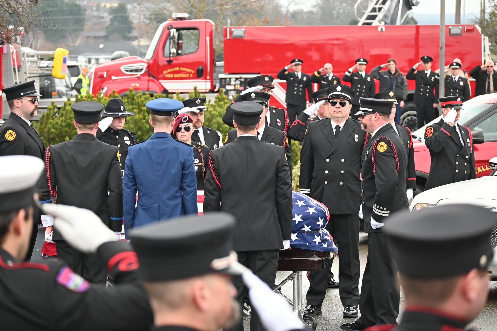 Firefighters pay tribute to Capt. Charles “Chad” Cate at a memorial service at Sequim High School on Saturday. (Michael Dashiell/Olympic Peninsula News Group)