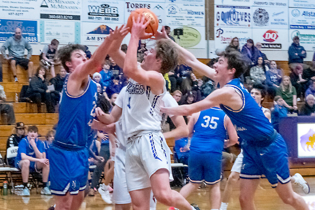 Sequim guard Zack Thompson, center, looks to score in a 64-44 Wolves win over North Mason on Tuesday. Thompson and Charlie Grider led Sequim in points with 16 each. (Emily Matthiessen/Olympic Peninsula News Group)