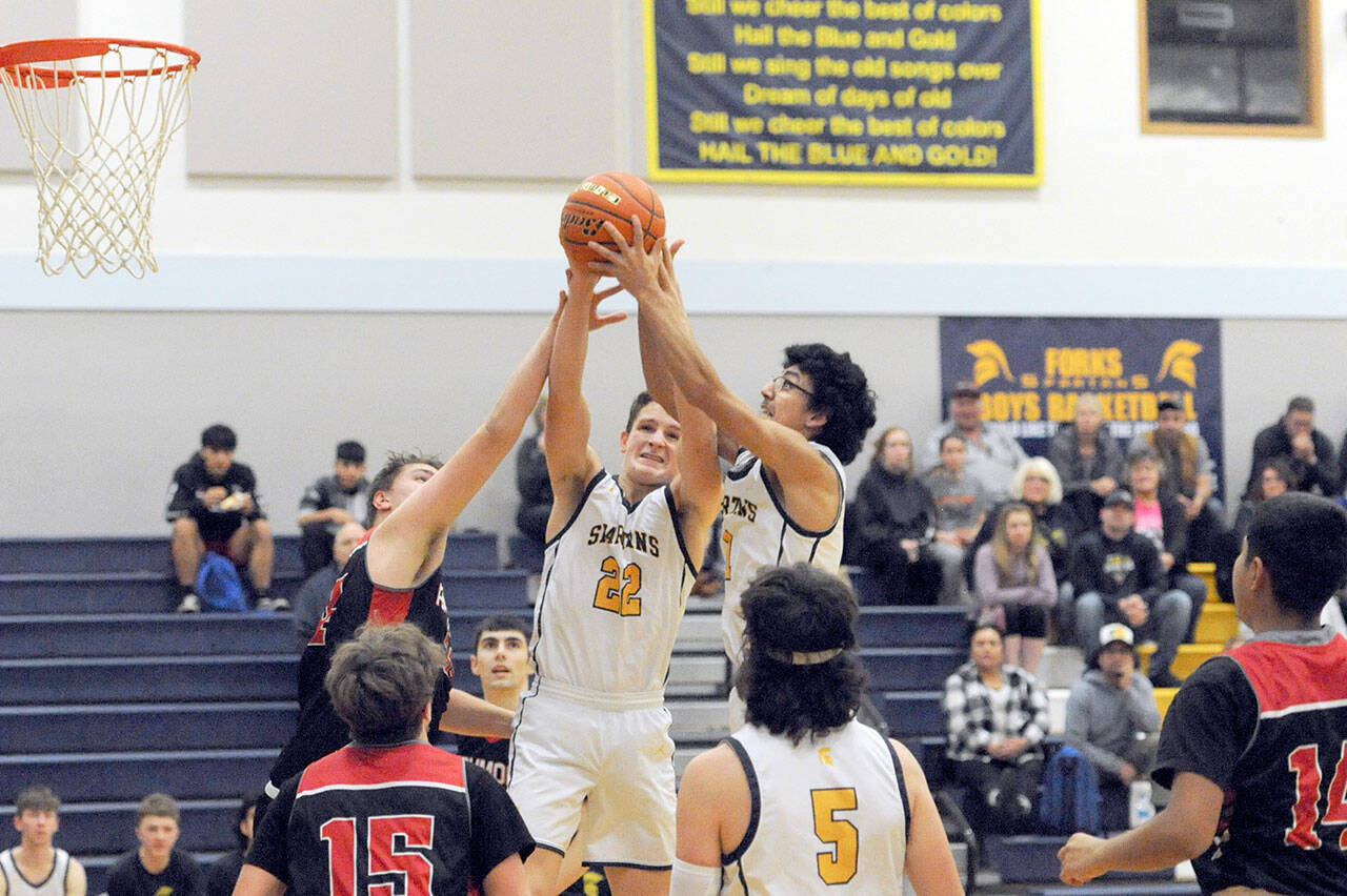 Forks’ Brody Lausche (22) and Brandon Galeana (right) compete with Raymond’s 6’7” Talan Yearout for ball control Wednesday night during the Spartans’ 54-53 Pacific League victory. (Lonnie Archibald/for Peninsula Daily News)