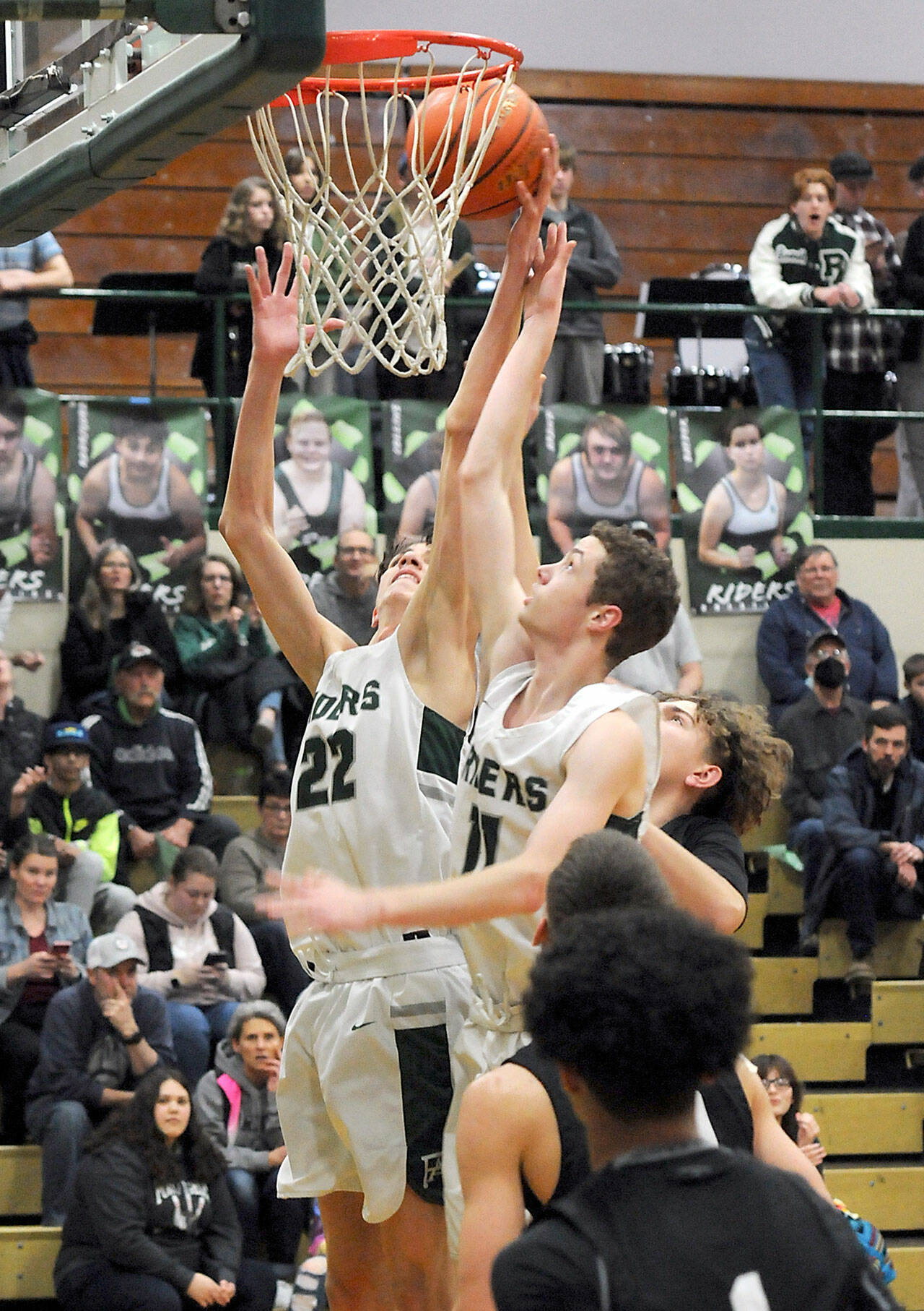 KEITH THORPE/PENINSULA DAILY NEWS Port Angeles’ Tyler Hunter, left, and teammate Dallas Dunning try to get the ball to the hoop as North Kitsap’s Jaxon Korsak, left, tries to break up the play on Thursday night at Port Angeles High School.