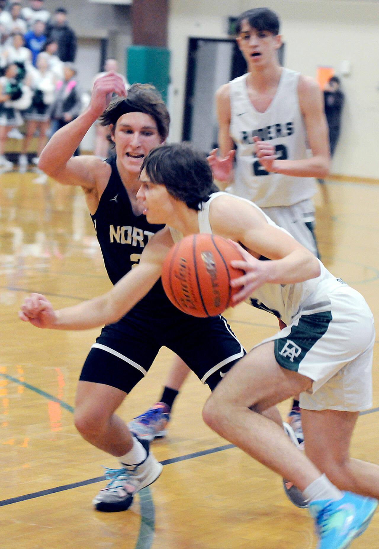 KEITH THORPE/PENINSULA DAILY NEWS Parker Nickerson of Port Angeles, front, drives to the lane as North Kitsap’s Mason Chmielewski defends his territory while Nickerson’s teammate, Tyler Hunter, looks on from behind on Thursday night in Port Angeles.
