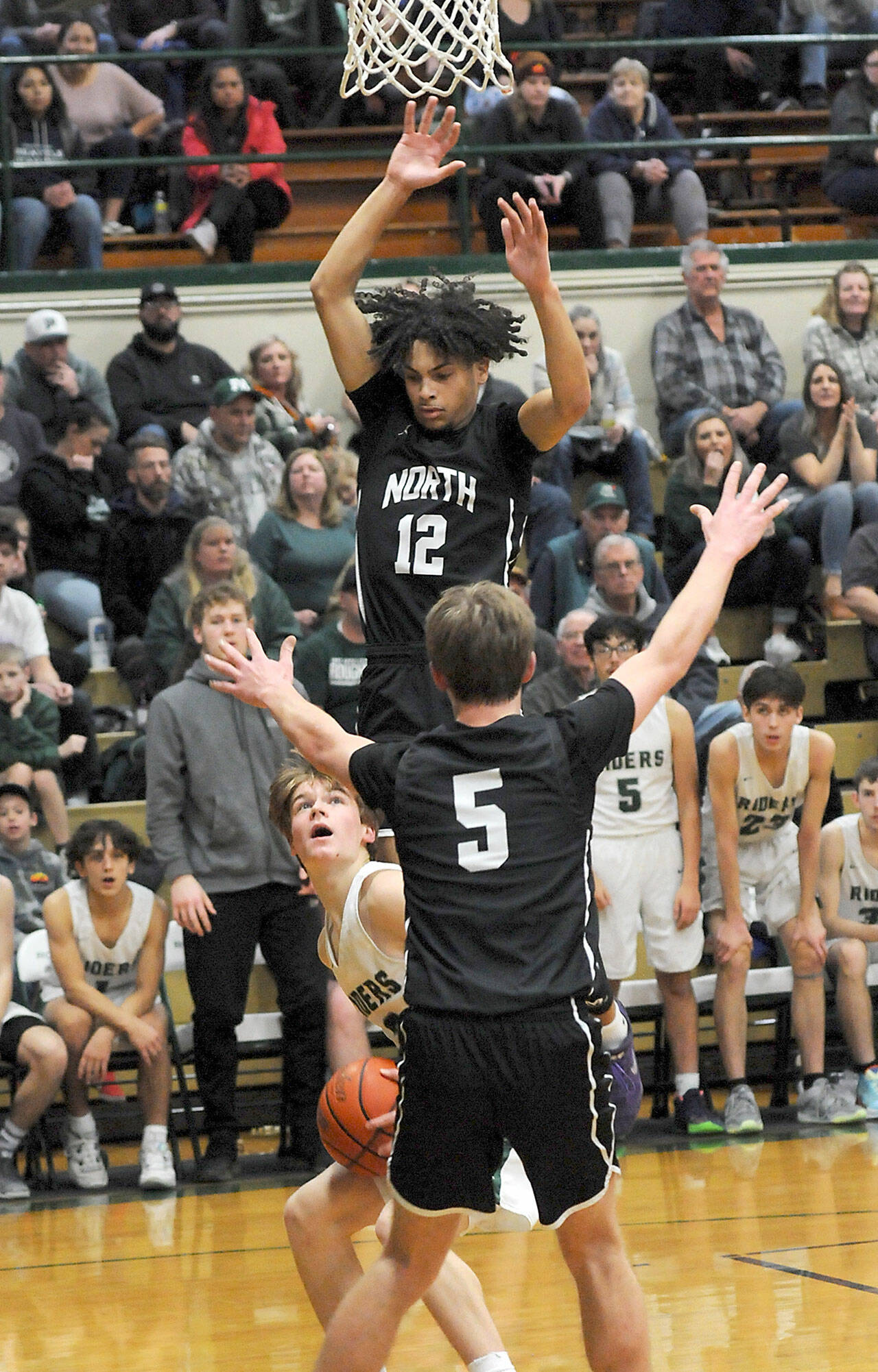 KEITH THORPE/PENINSULA DAILY NEWS Port Angeles’ Gus Halberg, left, waits for his chance at the basket as North Kitsap’s Harry Davies, top, and Ethan Gillespie provide interference on Thursday at Port Angeles High School.