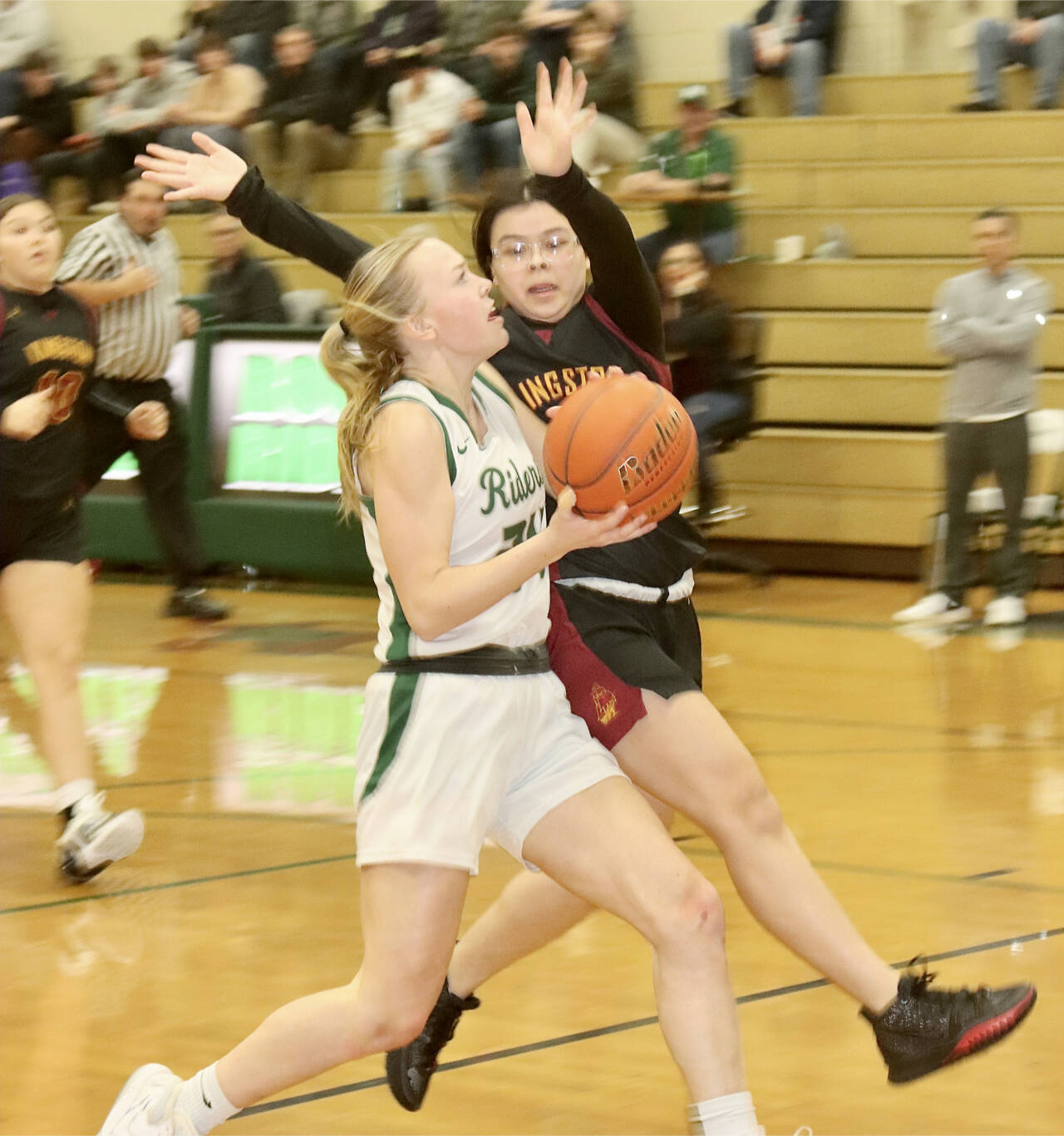 Port Angeles’ Anna Petty goes around a Kingston defender in the Roughriders’ 55-25 win at home Tuesday night. Petty scored 17 points to lead the Riders. (Dave Logan/for Peninsula Daily News)