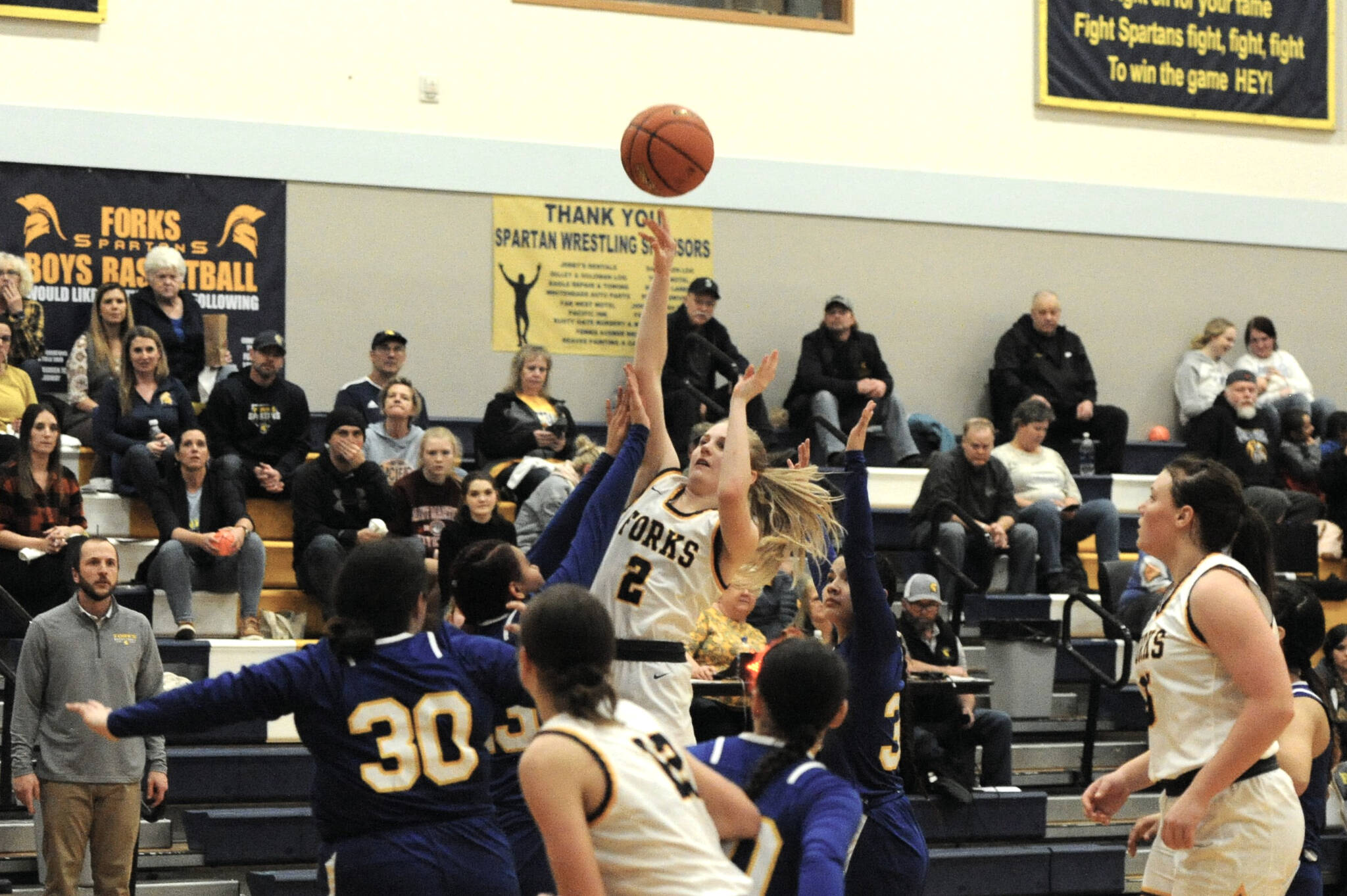 Forks’ Kadie Wood scores over a host of Chief Leschi Warriors during the Spartans’ 76-25 win Wednesday night. (Lonnie Archibald/for Peninsula Daily News)