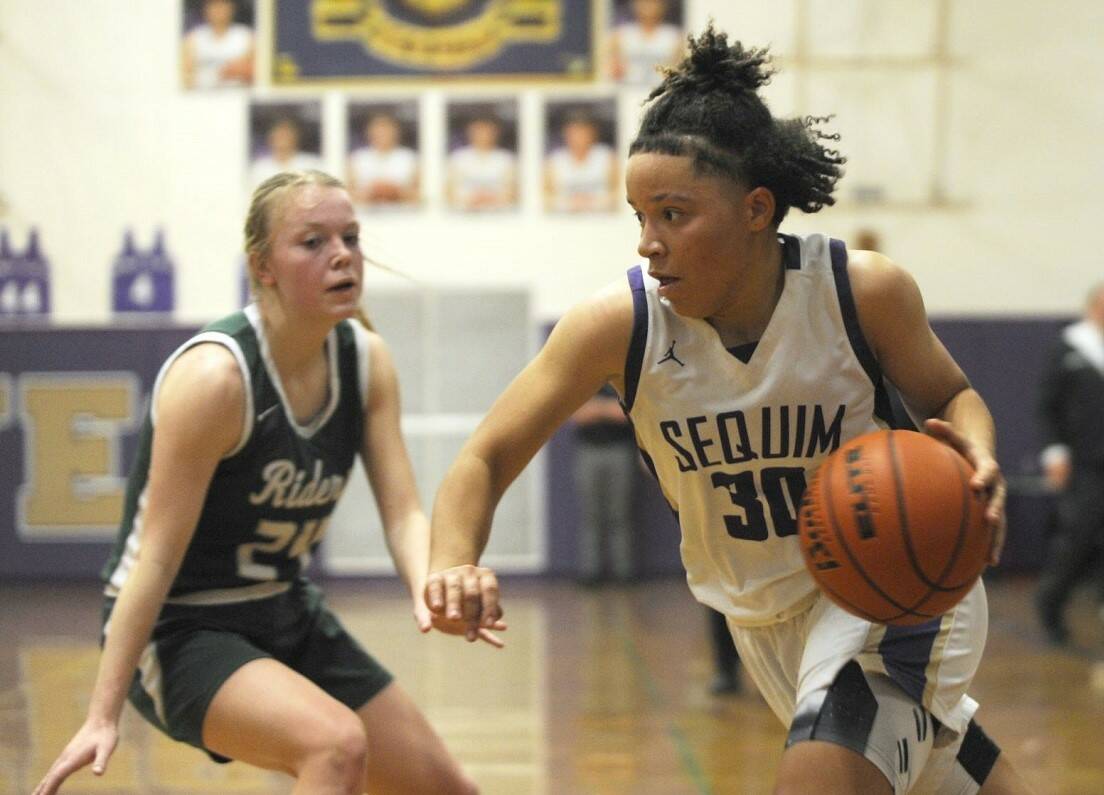 Sequim's Bobbi Mixon drives the ball against Port Angeles' Anna Petty in Thursday's game in Sequim. The Wolves won 57-46 thanks to a big third quarter. (Michael Dashiell/Olympic Peninsula News Group)