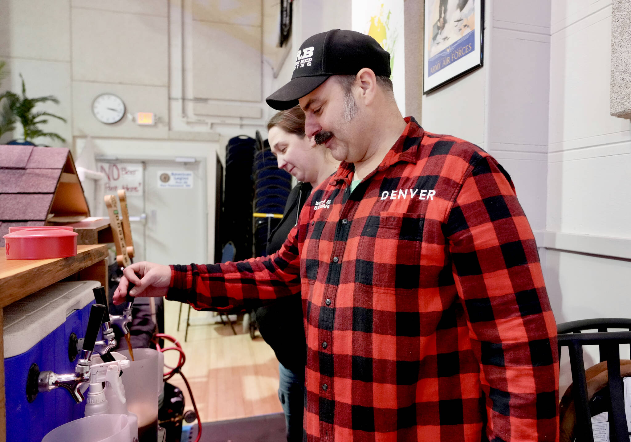 STEVE MULLENSKY/FOR PENINSULA DAILY NEWS Denver Smyth and wife Marianne, both with Western Red Brewery in Poulsbo, purge the Rubys Are Forever ale of air before the start of the 17th Strange Brew Fest in Port Townsend on Friday and Saturday at the American Legion Hall in downtown. There are 26 breweries from around western Washington that will be serving their own unique versions of strange brews.