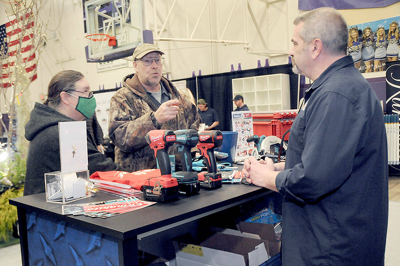 Jack and Marcella Ridge of Sequim talk about power tools with Tony Contestable, tool specialist with Hartnagel Building Supply of Port Angeles, right, during Saturday’s 2023 Building, Remodeling & Energy Expo in the Sequim High School gym. The two-day event, hosted by the North Peninsula Building Association, featured a variety of booths, displays and presentations dedicated to home building, repair and remodeling. (Keith Thorpe/Peninsula Daily News)