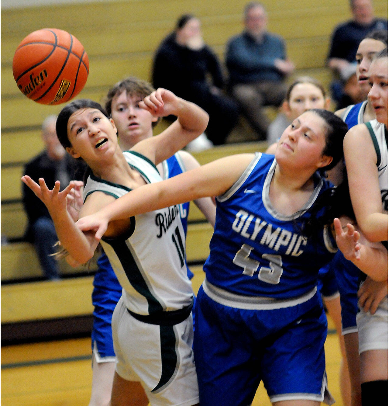 Port Angeles’ Lindsay Smith, left, stretches for a rebound next to Olympic’s Kylee Murphy during a Jan. 20 game in Port Angeles. The Roughriders play in regionals Friday night. (Keith Thorpe/Peninsula Daily News)
