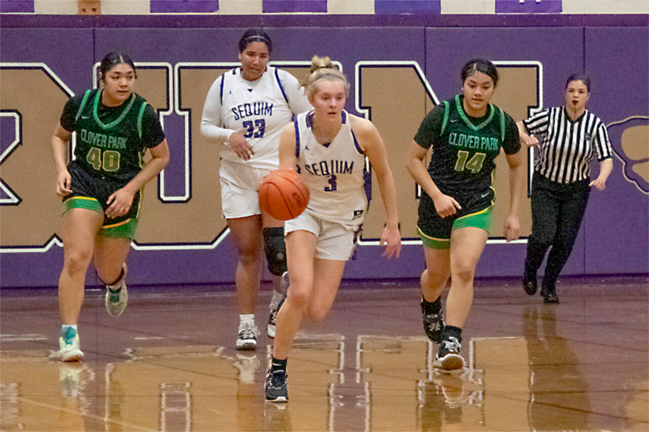 Sequim’s Jolen Vaara pushes the ball up the court with Jelissa Julmist trailing. The Wolves will play No. 1-ranked Ellensburg in the state regionals Friday night. (Emily Mathiessen/Olympic Peninsula News Group)