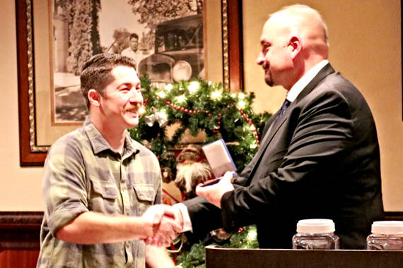 Sequim Police Officer Daniel Martinez receives a Purple Heart at a Sequim Police Department awards dinner in December 2022 from Sgt. Dave Campbell for his actions in stopping a man who allegedly attempted to kill him during a traffic stop. (Sequim Police Department)