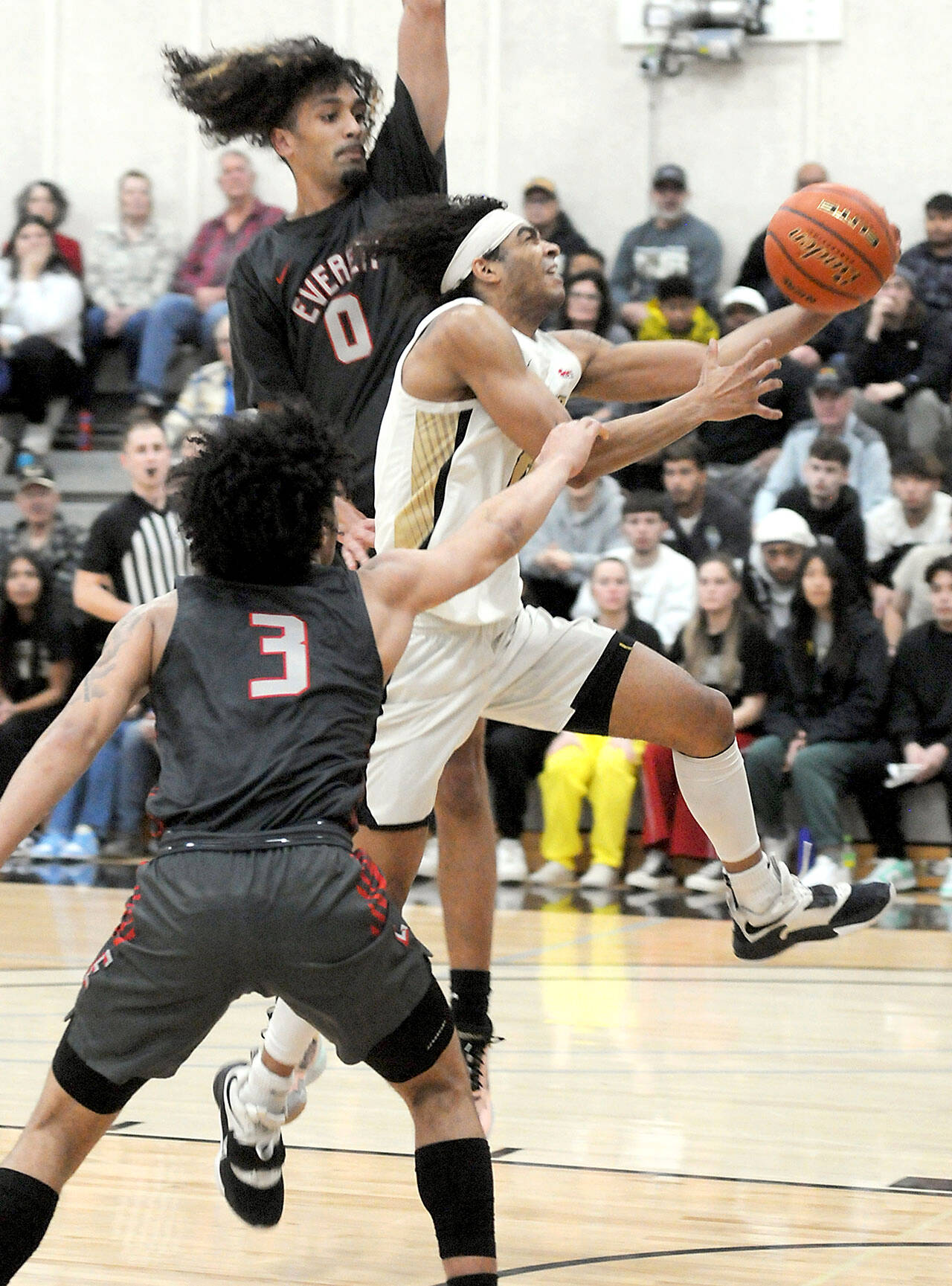 Peninsula’s Roosevelt Williams Jr. looks for the layup as Everett’s Tyriq Luke, front, and Leon Sayers hold the lane on Wednesday’s regular season finale at Peninsula College in Port Angeles. (Keith Thorpe/Peninsula Daily News)