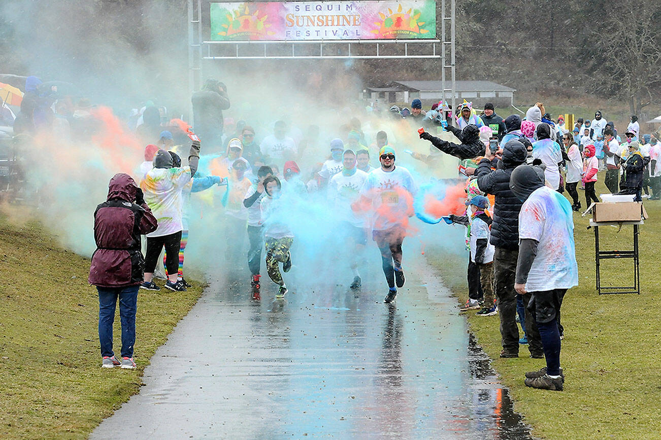 Participants in the 5K Sun Fun Color Run emerge from clouds of tempera paint while being pelted by rain and snow during Saturday’s Sequim Sunshine Festival at Carrie Blake Park and the Albert Haller Play Fields with additional events at Pioneer Park. Inclement weather on Saturday forced organizers to move many entertainment events indoors. (Keith Thorpe/Peninsula Daily News)