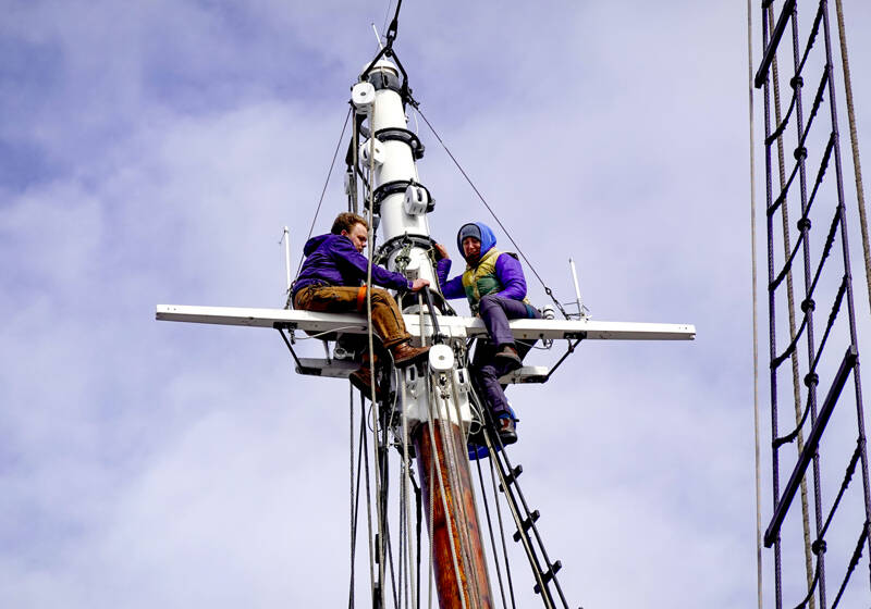 Workers install rigging atop the 60-foot-tall foremast on the 133-year-old historic tall ship Adventuress. The ship has been on the hard at the Port Townsend Boat Haven since last December and is expected to go in the water by the end of the week. (Steve Mullensky/for Peninsula Daily News)