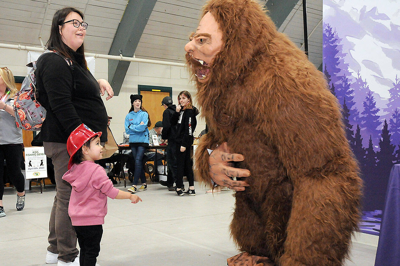Annalise Sanchez, 2, along with her mother, Yvonne Bolstron of Port Angeles, look in awe at Sasquatch, portrayed by Jess Grello, an organizer of the annual Squatchcon comic and arts convention, during Saturday’s Kiwanis KidsFest and Clallam County Community Safety Day in and around Vern Burton Community Center in Port Angeles. The free event brought together a variety of organizations and agencies to promote parenting and community awareness. (Keith Thorpe/Peninsula Daily News)