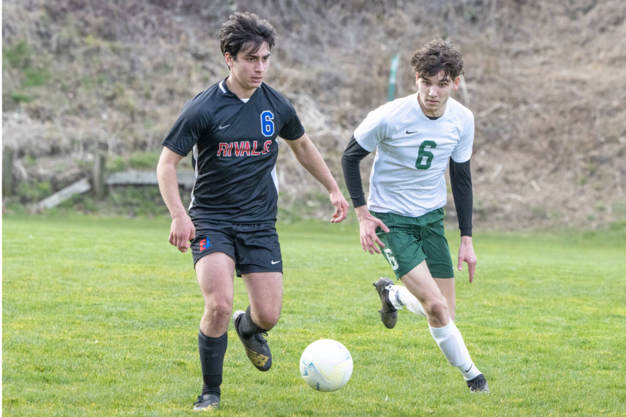 East Jefferson’s Isaac Gurney, left, dribbles the ball against Port Angeles’ Keane McClain at Memorial Stadium in Port Townsend on Saturday. Port Angeles won 7-0. (Steve Mullensky/for Peninsula Daily News)